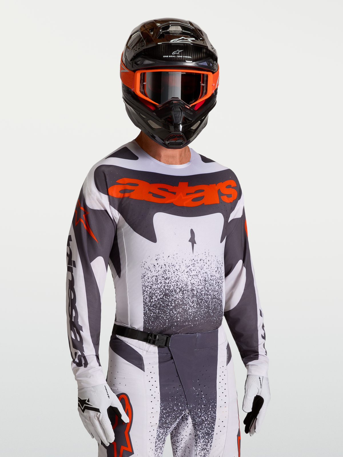 Alpinestars Maglia Techstar Swan, maglia da motocross uomo grigia e rosso fluo, vestibilità racing, indossata con casco.