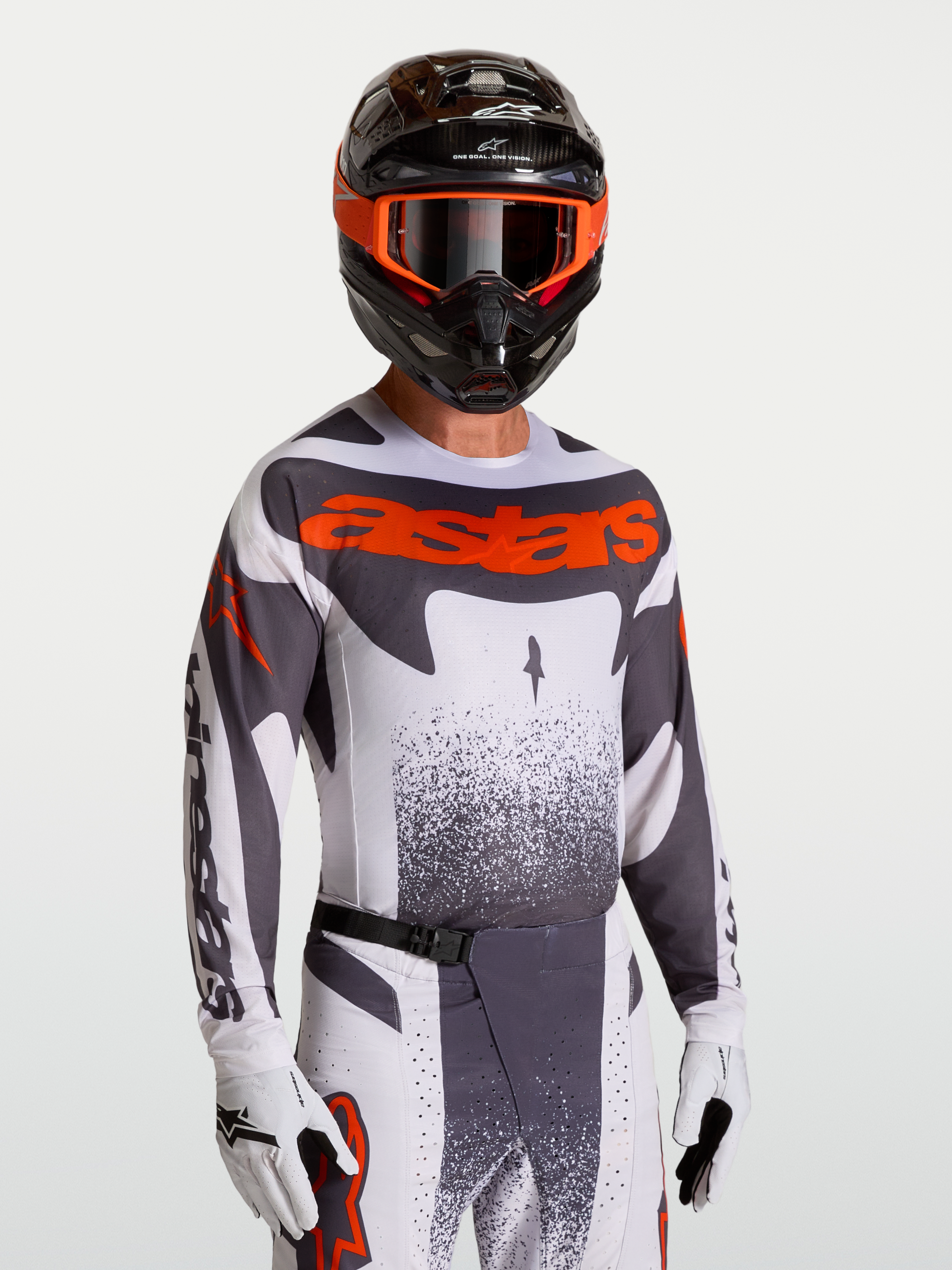 Alpinestars Maglia Techstar Swan, maglia da motocross uomo grigia e rosso fluo, vestibilità racing, indossata con casco.