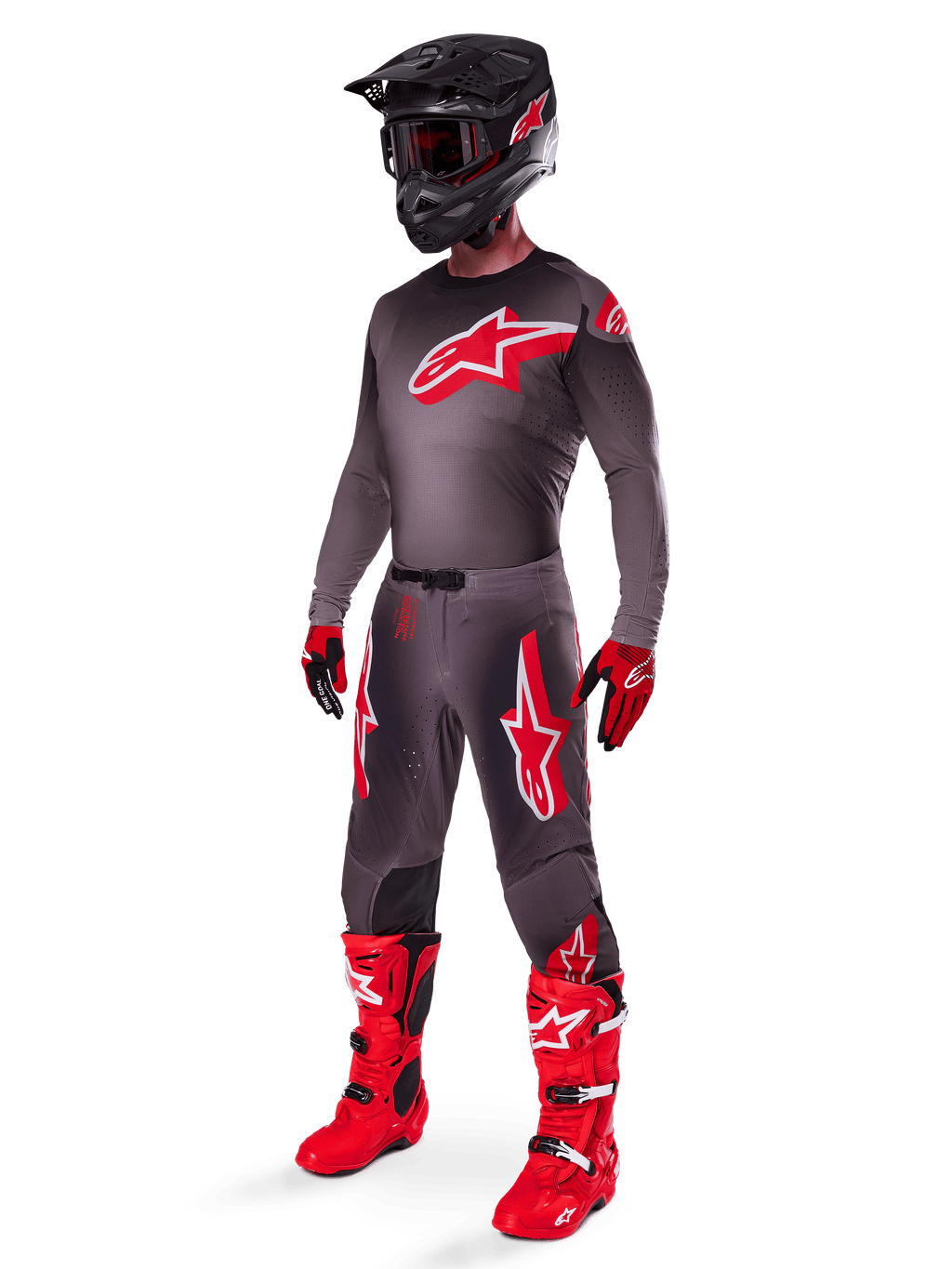 Pilota di motocross con abbigliamento completo da gara, maglia Supertech Lipan 2025 Smoke Bright Red, pantaloni grigi coordinati con grafiche rosse, casco nero con dettagli rossi, stivali rosso acceso e guanti rossi e neri, completo professionale coordinato per corse fuoristrada