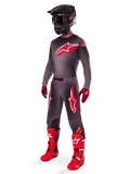 Alpinestars 2025 Supertech Lipan Gear Set, abbigliamento completo da motocross, maglia grigio scuro e rossa con grande logo a stella, pantaloni coordinati con grafiche a stella, guanti rossi, stivali rosso acceso con fibbie bianche e casco nero opaco con occhiali rossi
