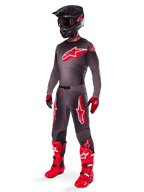 Alpinestars 2025 Supertech Lipan Gear Set, abbigliamento completo da motocross, maglia grigio scuro e rossa con grande logo a stella, pantaloni coordinati con grafiche a stella, guanti rossi, stivali rosso acceso con fibbie bianche e casco nero opaco con occhiali rossi