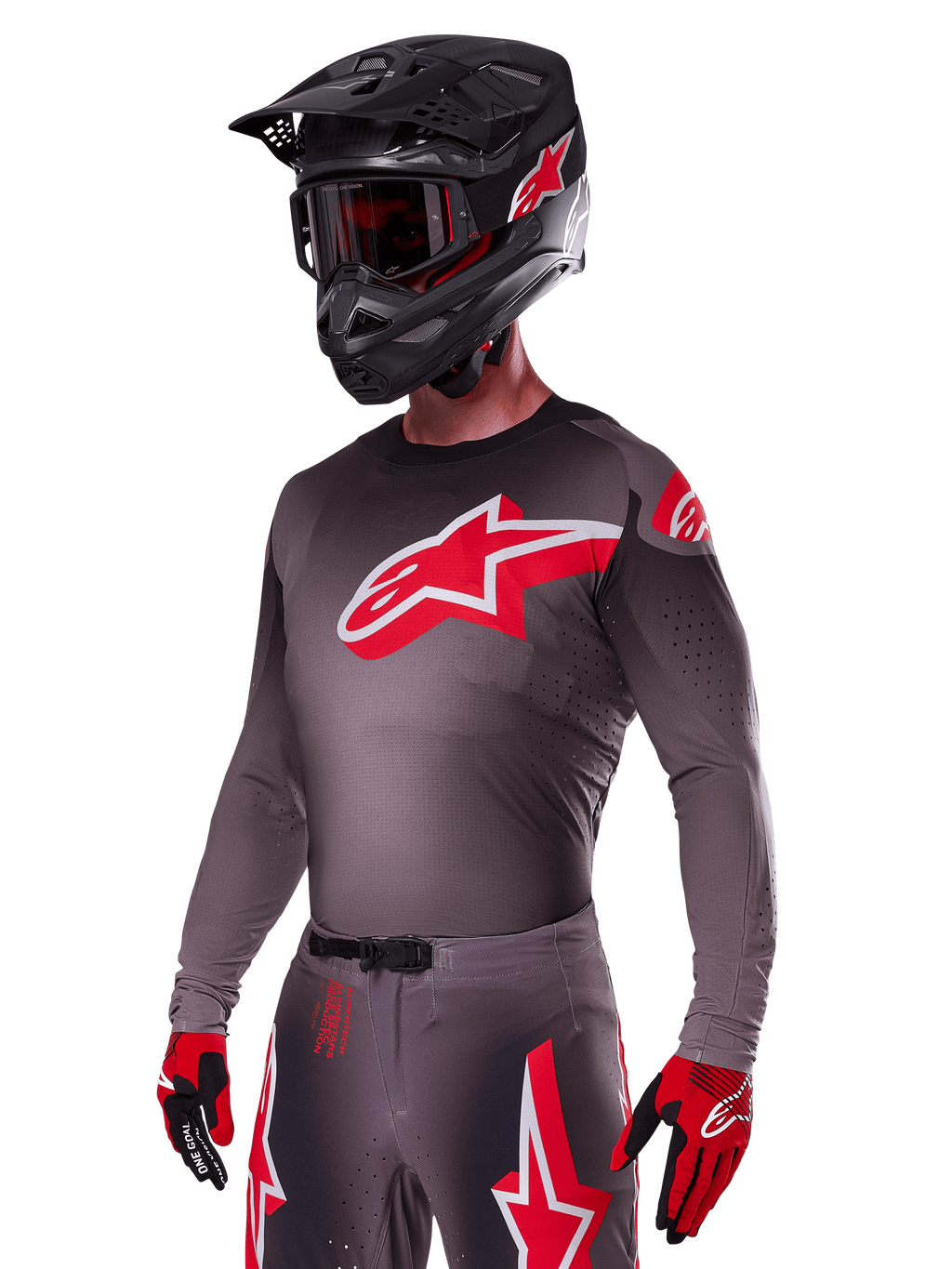 Set Alpinestars 2025 Supertech Lipan, pilota di motocross che indossa maglia e pantaloni grigio scuro con accenti rossi e bianchi, con un grande logo Alpinestars rosso sul petto, perforazioni al laser per la ventilazione, casco nero coordinato, maschera rossa e guanti rossi e neri.