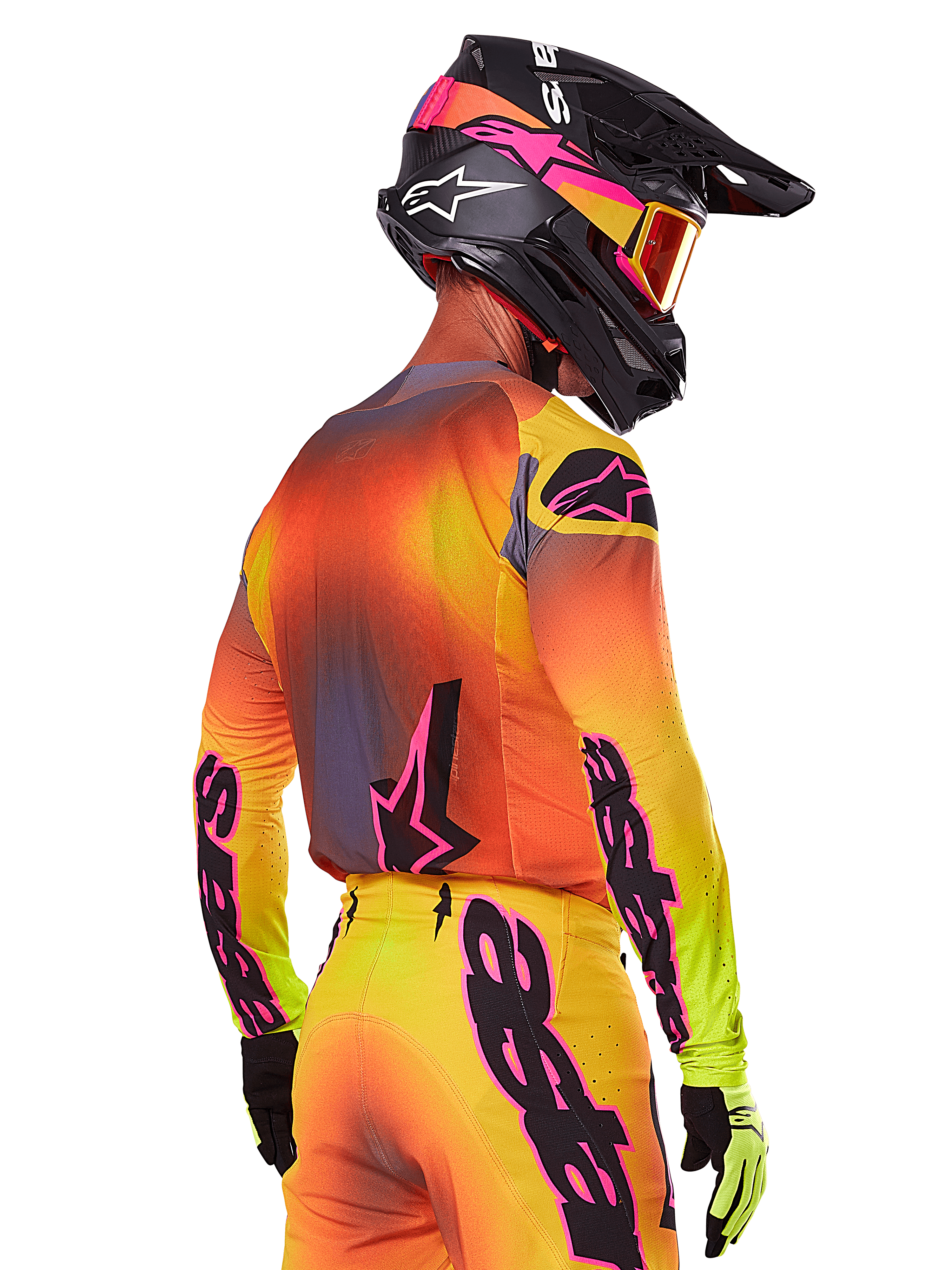 Pilota di motocross visto da una prospettiva posteriore-laterale con il set Alpinestars 2025 Supertech Lipan, caratterizzato da un gradiente giallo, arancione e rosso con branding nero e rosa, casco nero con accenti rosa e maschera arancione, abbigliamento professionale per gare off-road.