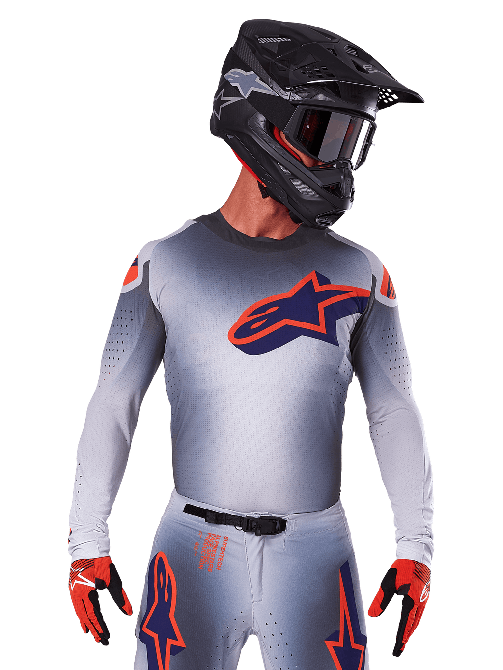 Alpinestars 2025 Supertech Lipan Jersey, maglia da motocross, grigio con accenti arancioni e blu navy, maglia tecnica a maniche lunghe con dettagli di ventilazione traforati, indossata con casco nero e guanti rossi, design racing elegante