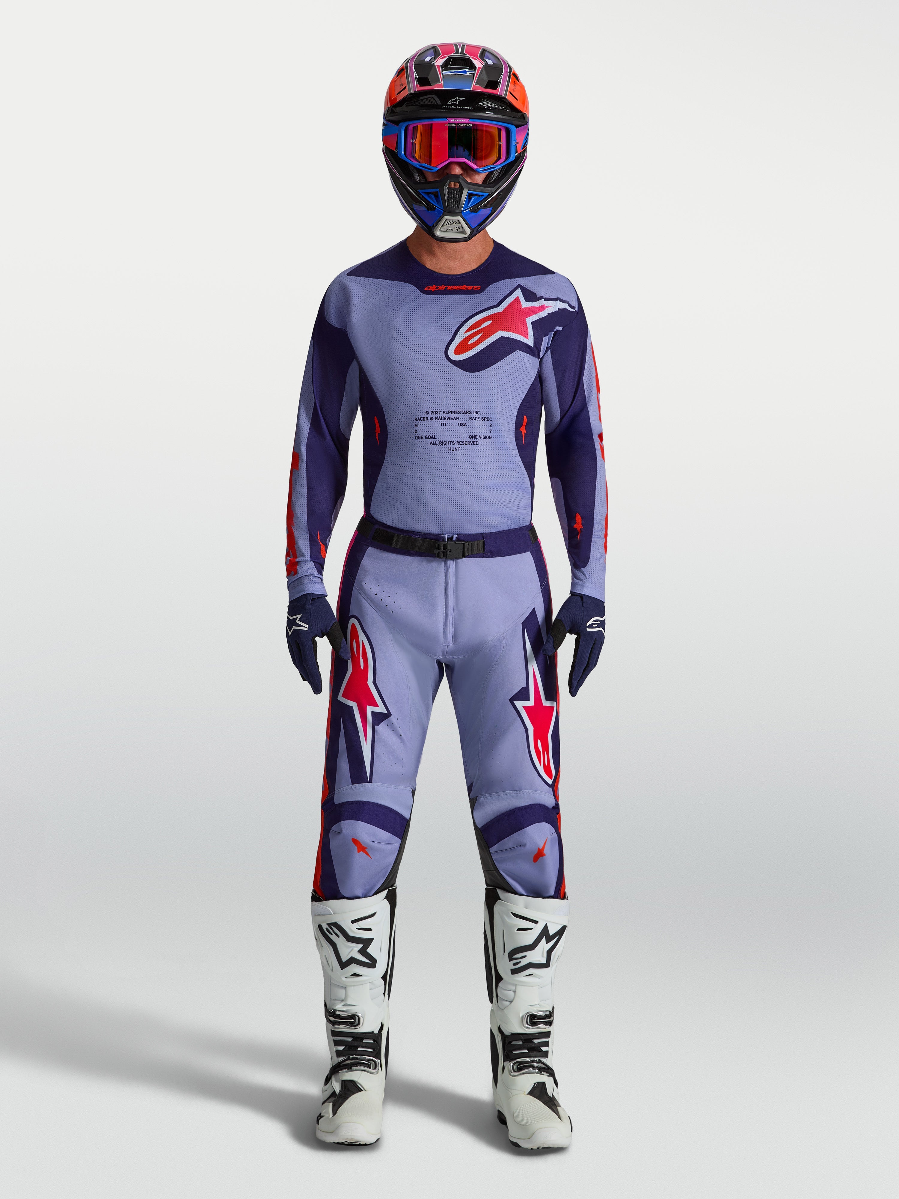 Maglia Racer Air Hunt Alpinestars, maglia da motocross da uomo viola e rosa fluo in mesh ventilato, indossata con kit completo da off-road.