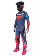 Alpinestars Set Techstar Dreem 2025, abbigliamento completo da motocross con maglia grigia e blu e dettagli rossi, pantaloni coordinati con tocchi di rosa, casco nero, stivali rosa acceso e guanti bianchi e neri