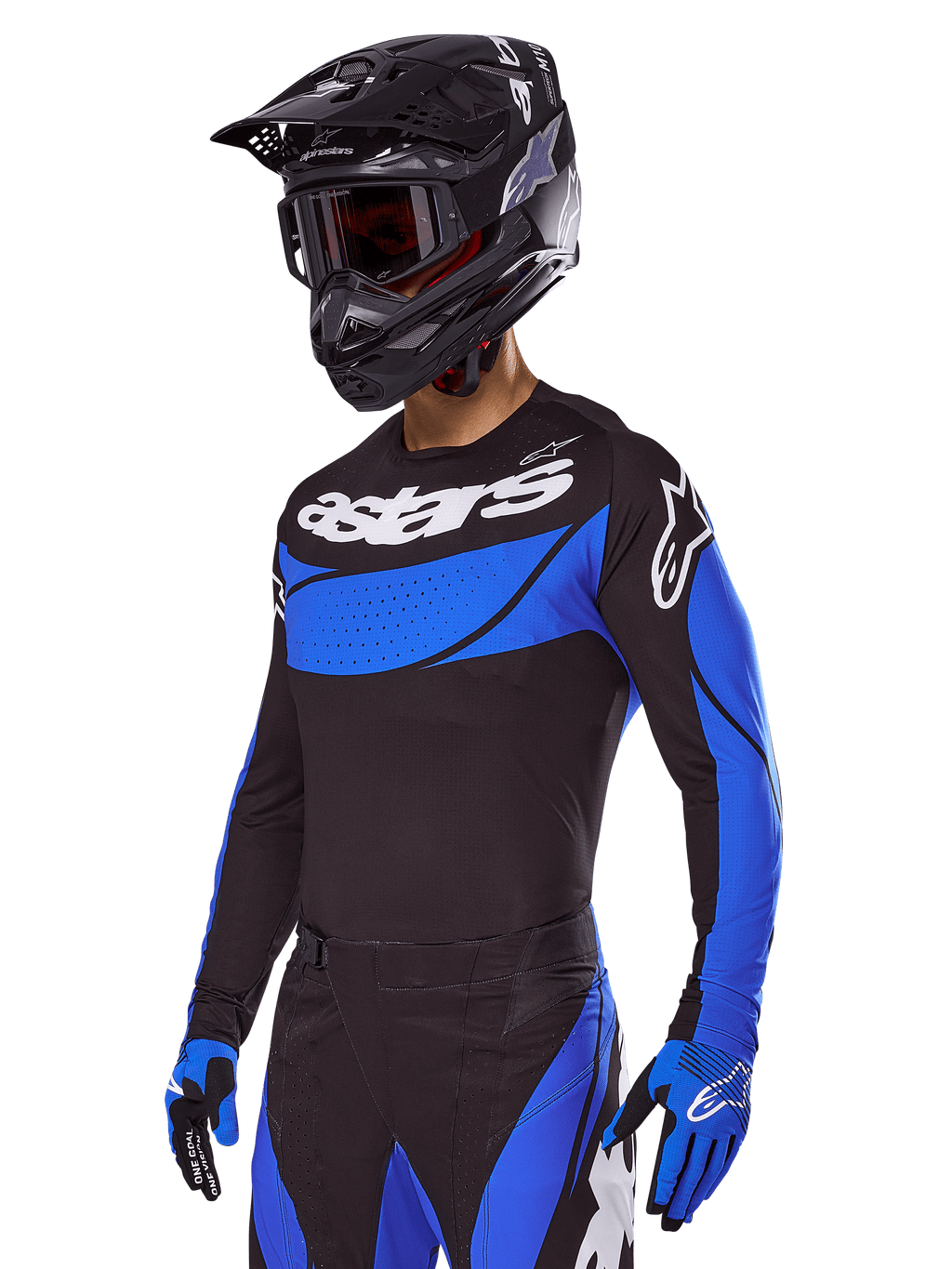 Pilota di motocross con il set Alpinestars Techstar Dreem 2025, maglia nera con pannelli blu stile traforato e branding bianco, pantaloni coordinati neri e blu, casco da corsa nero e guanti blu, abbigliamento tecnico per motocross off-road.