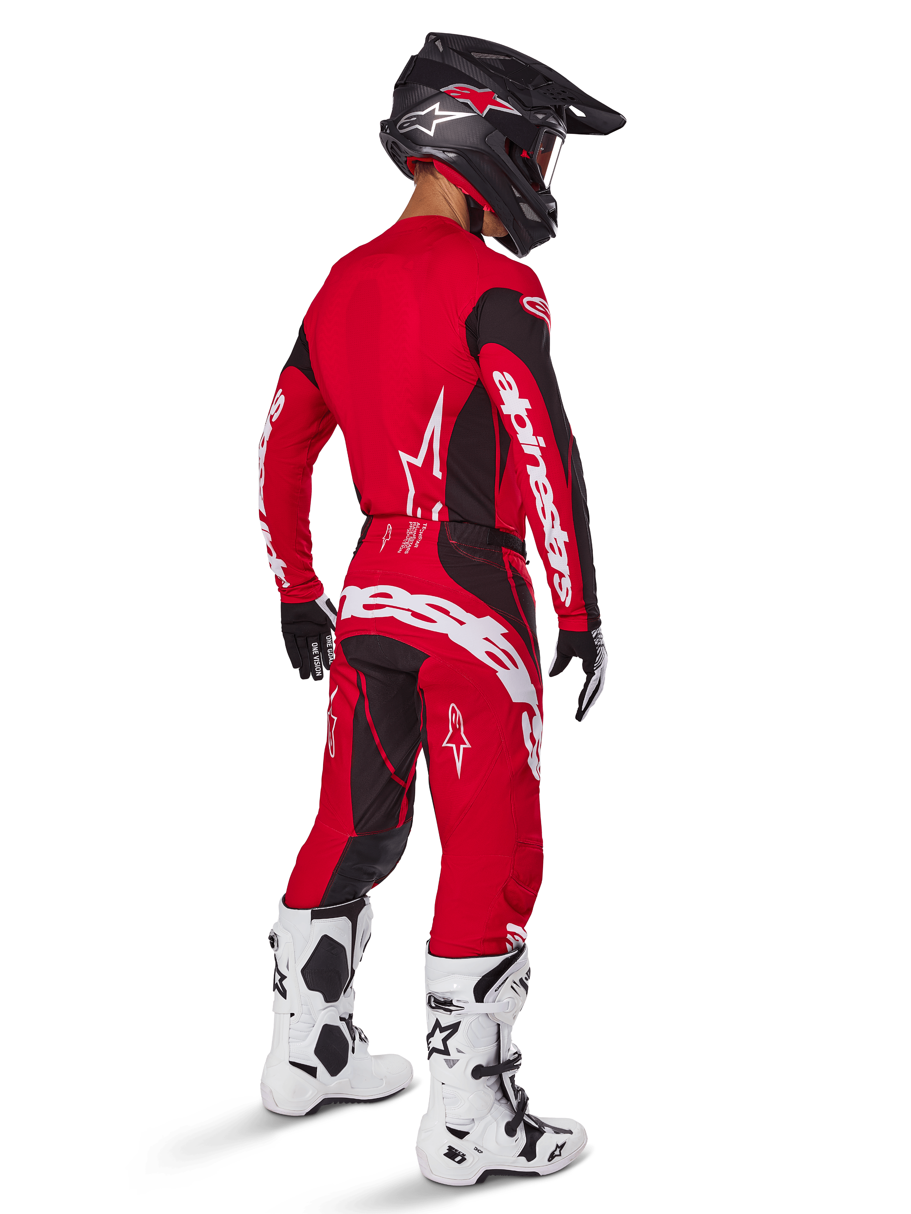 Pilota di motocross che indossa il set completo Alpinestars Techstar Dreem 2025 in rosso acceso e nero, con loghi bianchi su maglia e pantaloni, abbinato a casco nero, stivali bianchi e neri e guanti neri e bianchi, vista posteriore di tre quarti.