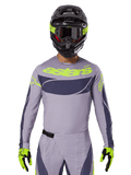 Maglia e set gear Techstar Dreem 2025, completo da gara motocross, grigio chiaro e grigio scuro con dettagli giallo neon, marchio 'astars', indossato con casco nero, occhiali e guanti coordinati, materiale tecnico traforato per prestazioni off-road
