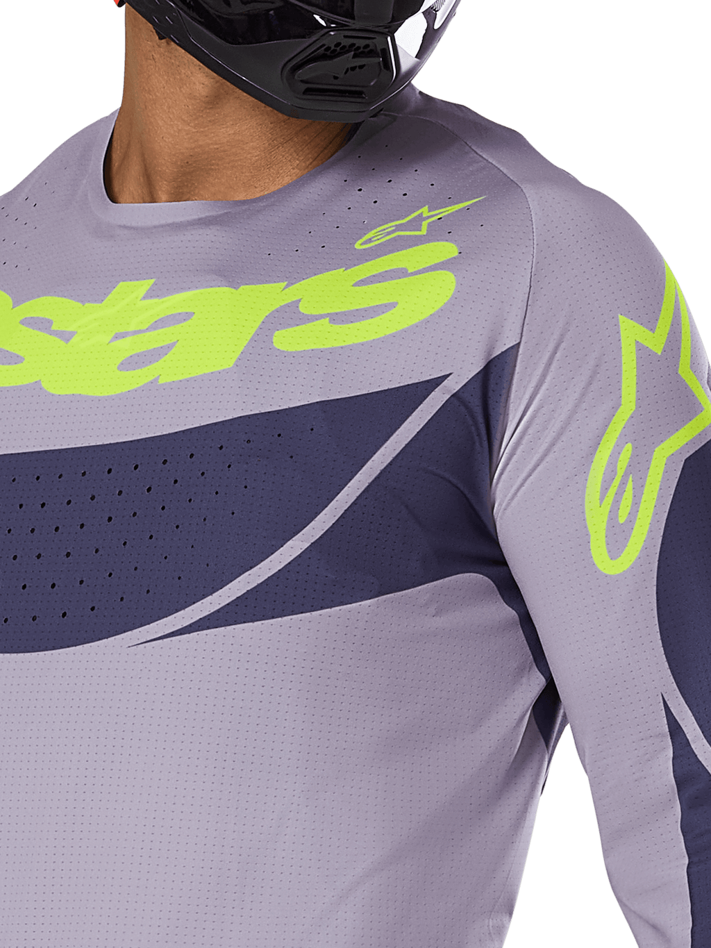 Alpinestars Techstar Dreem Jersey 2025, maglia da motocross, grigio e blu navy con logo verde lime acceso, primo piano del pilota con casco nero, con perforazioni tagliate al laser per la ventilazione