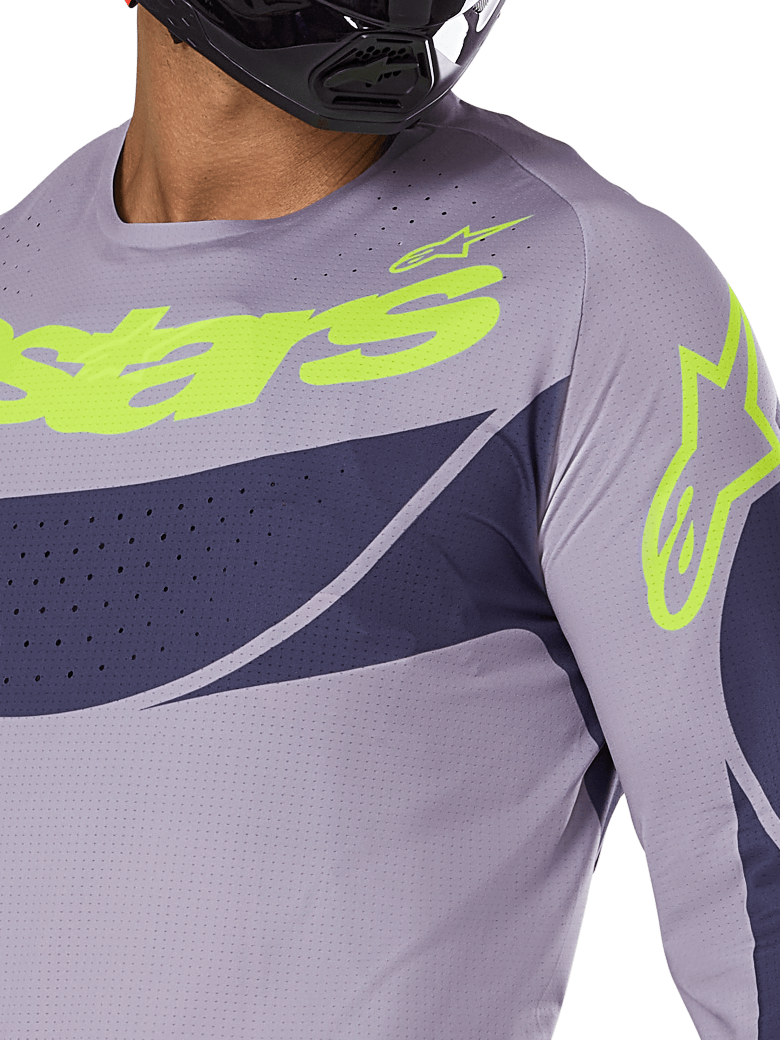 Alpinestars Techstar Dreem Jersey 2025, maglia da motocross, grigio e blu navy con logo verde lime acceso, primo piano del pilota con casco nero, con perforazioni tagliate al laser per la ventilazione