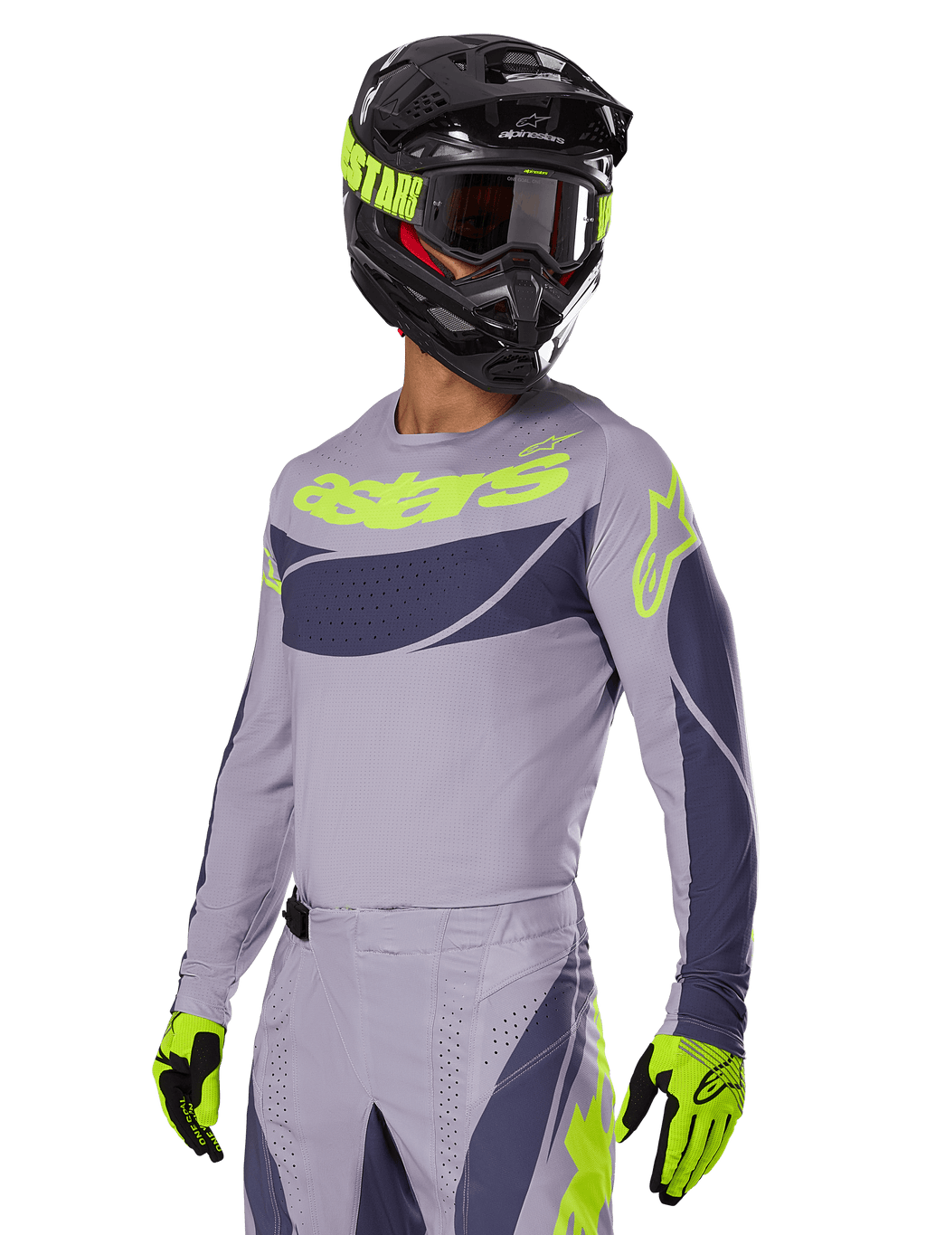 Pilota di motocross che indossa la maglia Alpinestars 2025 Techstar Dreem in grigio e grigio scuro, con logo 'astars' giallo neon sul petto, completata da casco, maschera e guanti coordinati per un look da gara off-road.