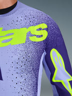 Maglia Alpinestars Supertech Scenz 2026 in Viola Giallo Fluo, primo piano di petto e spalla con perforazioni laser, materiale mesh elasticizzato e branding giallo fluo per prestazioni motocross professionali.