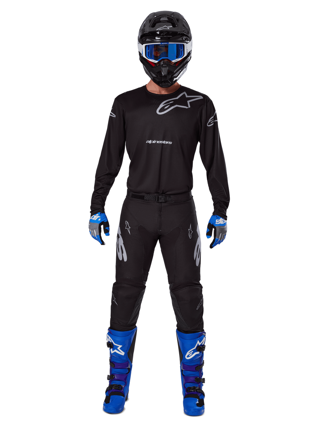 Alpinestars 2025 Racer Graphite Gear Set, pilota di motocross con abbigliamento completo da gara, maglia nera a maniche lunghe con loghi Alpinestars grigi, pantaloni neri, casco nero con occhiali blu, guanti blu e grigi, stivali blu e neri, outfit coordinato per gare di motocross fuoristrada