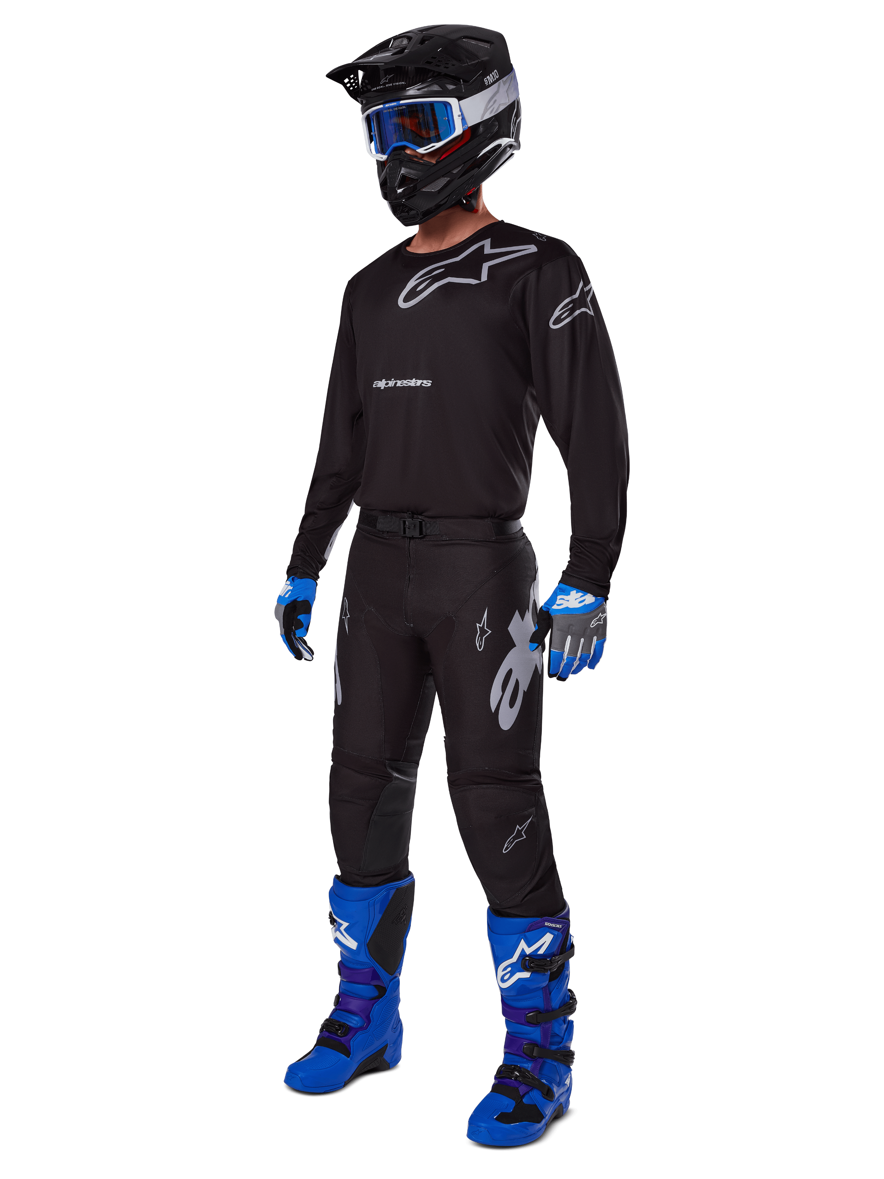 Set completo motocross Alpinestars Racer Graphite 2025, outfit completo da motocross, maglia e pantaloni neri e grigi con loghi argento, casco nero con occhiali a lenti blu, guanti blu e neri, stivali blu brillante, equipaggiamento professionale per gare fuoristrada