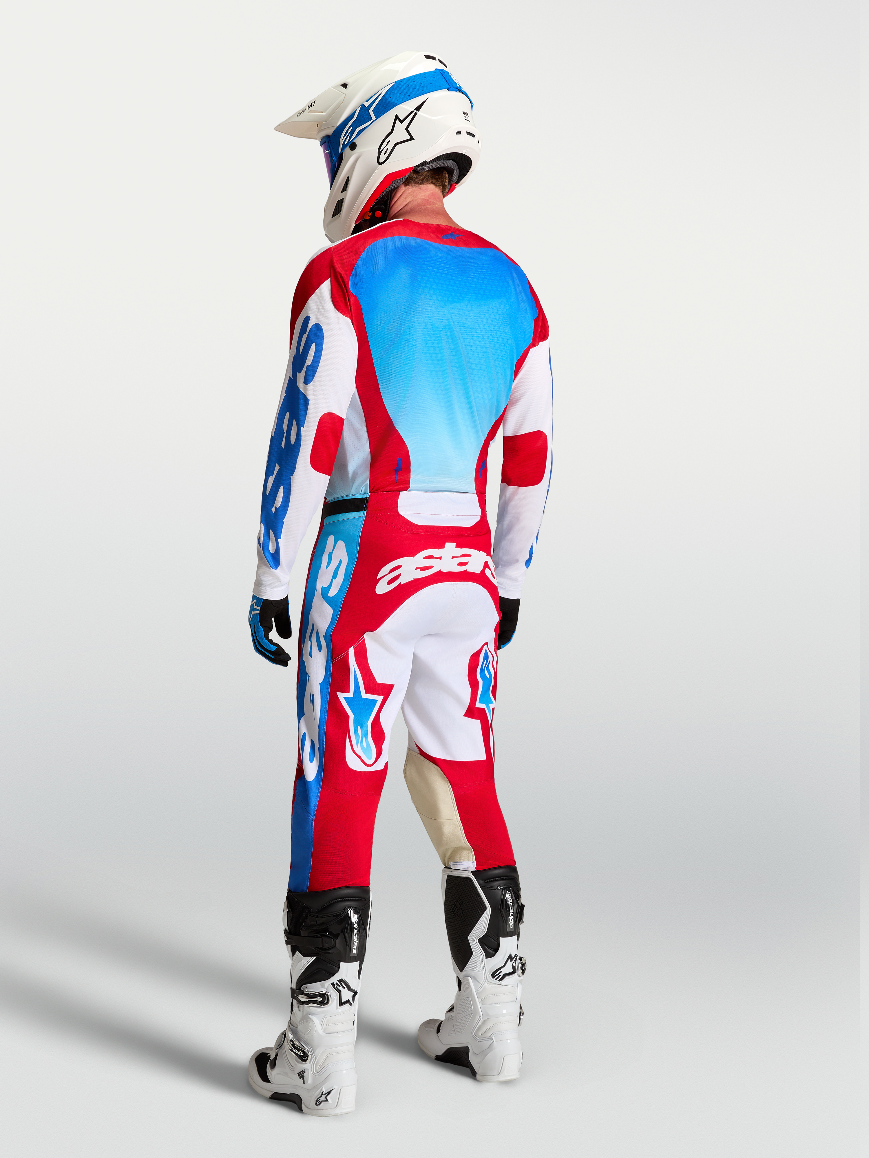 Alpinestars Pantaloni Racer Hunt AND Racer Hunt Gear Set, abbigliamento da motocross da uomo, rosso, bianco e blu, vista posteriore su pilota.