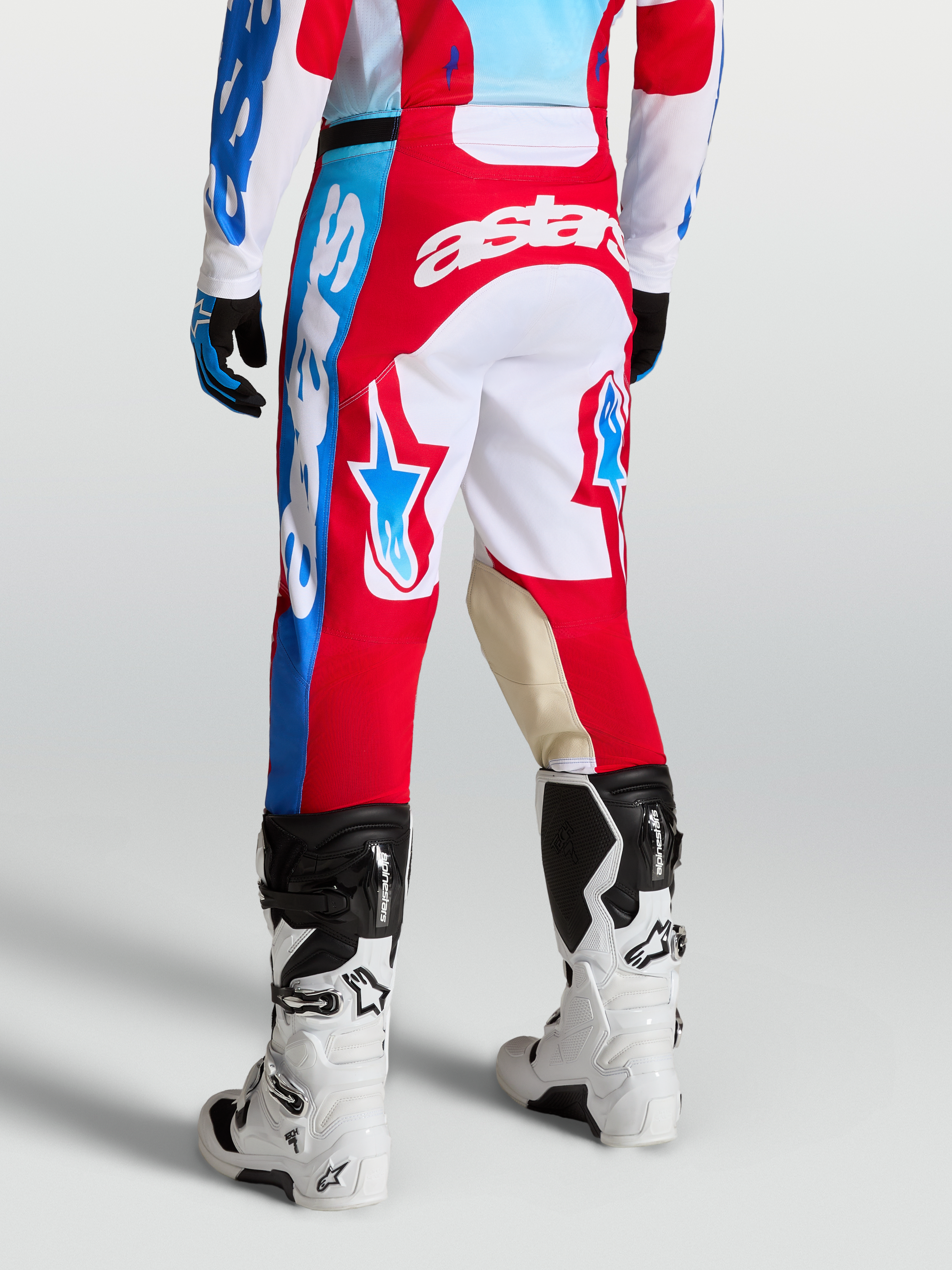 Alpinestars Pantaloni Racer Hunt, pantaloni motocross da uomo, rosso e bianco, con grafiche a stella e pannelli in pelle di capra sulle ginocchia, vista posteriore su modello
