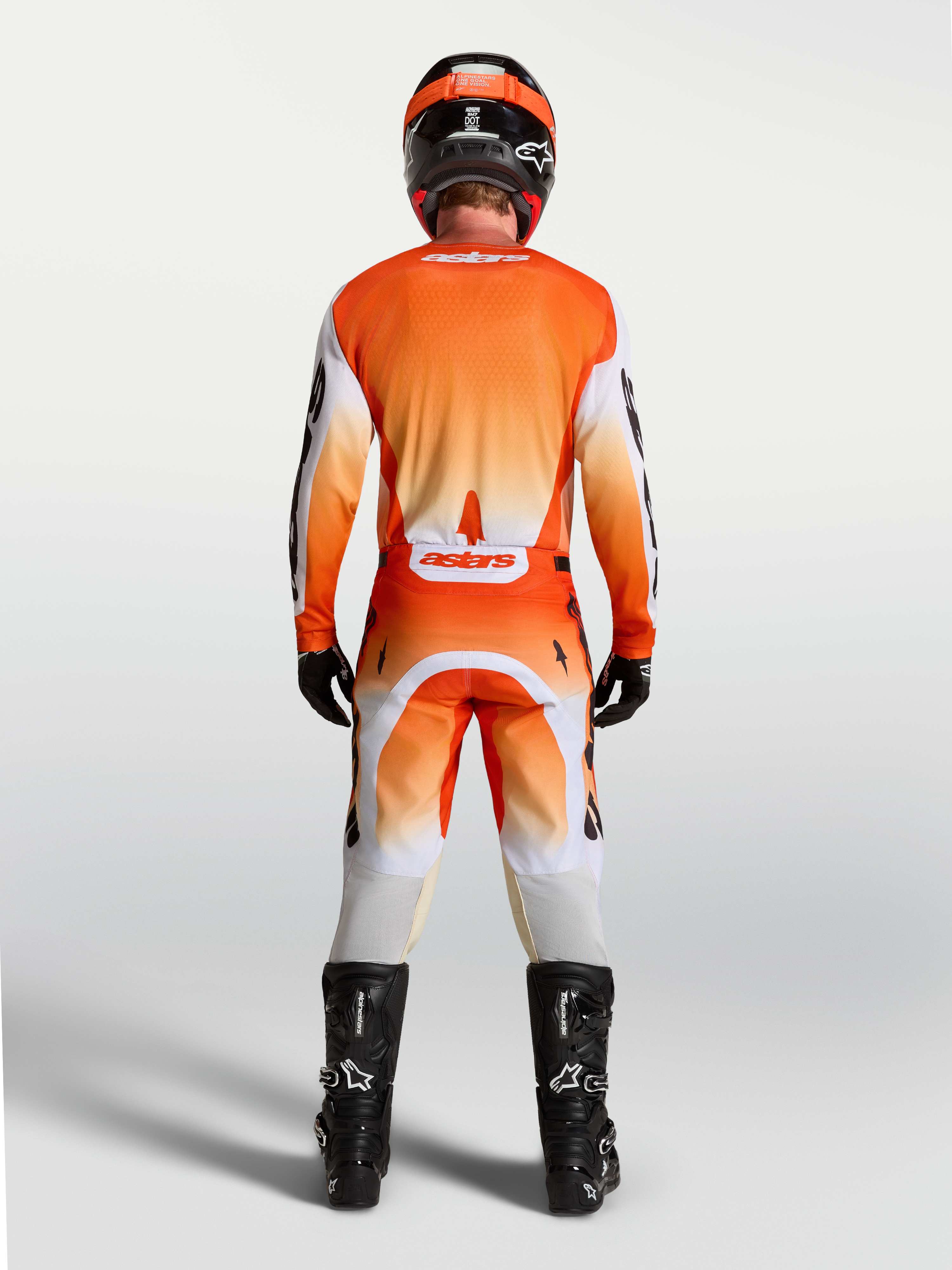 Alpinestars Maglia Racer Amber, maglia da motocross per uomo, vista posteriore su modello, arancione e bianca, tessuto tecnico traspirante, vestibilità ergonomica da gara per off-road.