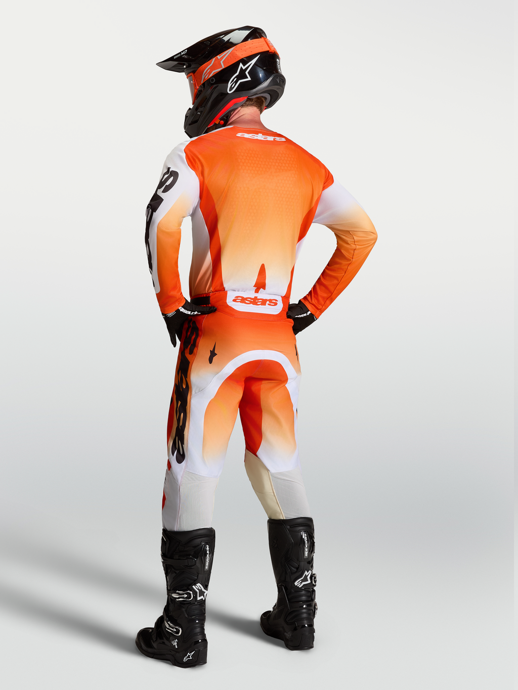 Alpinestars pantaloni Racer Amber e Gear Set, completo motocross uomo arancione e bianco, vista posteriore su modello.