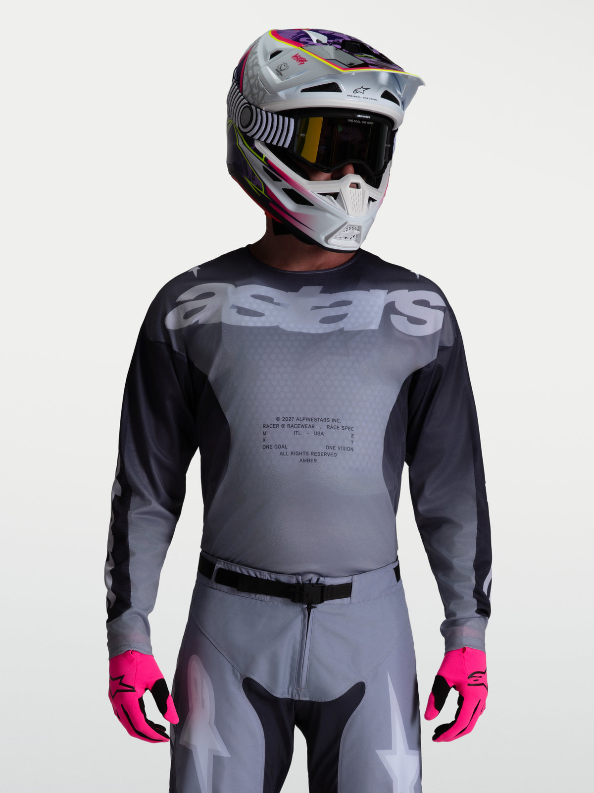 Alpinestars Maglia Racer Amber, maglia da motocross per uomo, grigia e antracite, in poliestere traspirante, indossata con casco e guanti rosa