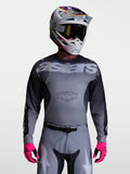 Alpinestars Maglia Racer Amber, maglia da motocross per uomo, grigia e antracite, in poliestere traspirante, indossata con casco e guanti rosa