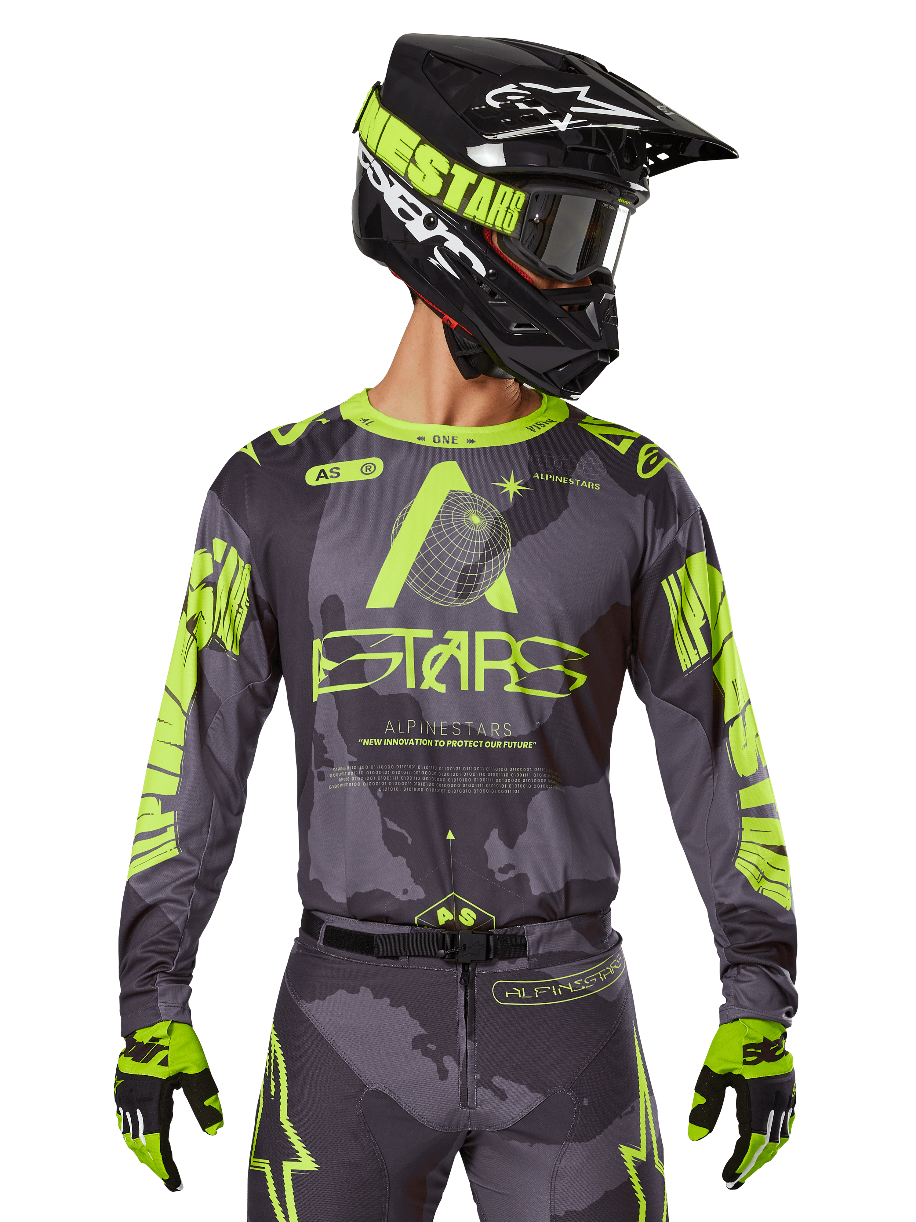 Alpinestars 2025 Racer Hollow Jersey, maglia da motocross, mimetico scuro e giallo neon, indossata con pantaloni coordinati, casco nero e giallo con occhiali e guanti neri, con logo Alpinestars e design mimetico