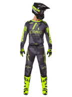 Pilota di motocross con abbigliamento da gara completo, maglia Alpinestars Racer Hollow 2025 e pantaloni coordinati in Dark Camo Yellow Fluo, con vivaci grafiche giallo fluorescente su sfondo mimetico grigio scuro, abbinati a guanti coordinati, stivali giallo fluo brillante e casco nero.