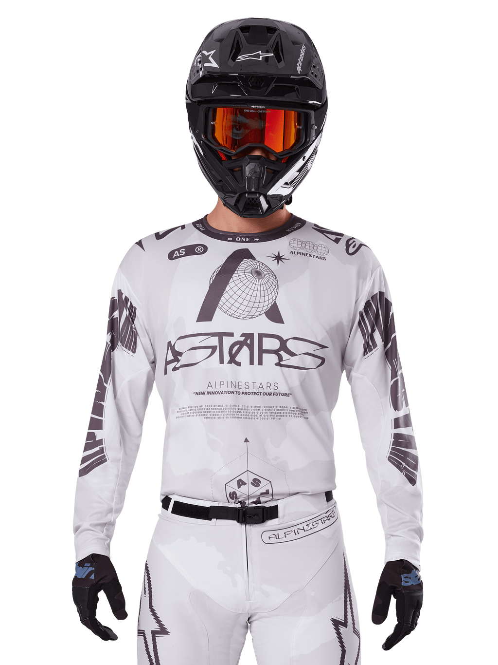 Alpinestars 2025 Racer Hollow Jersey, maglia da motocross bianca e nera, indossata con pantaloni MX bianchi coordinati e un casco nero con maschera arancione, caratterizzata da branding Alpinestars e grafiche a globo, abbigliamento professionale per corse fuoristrada