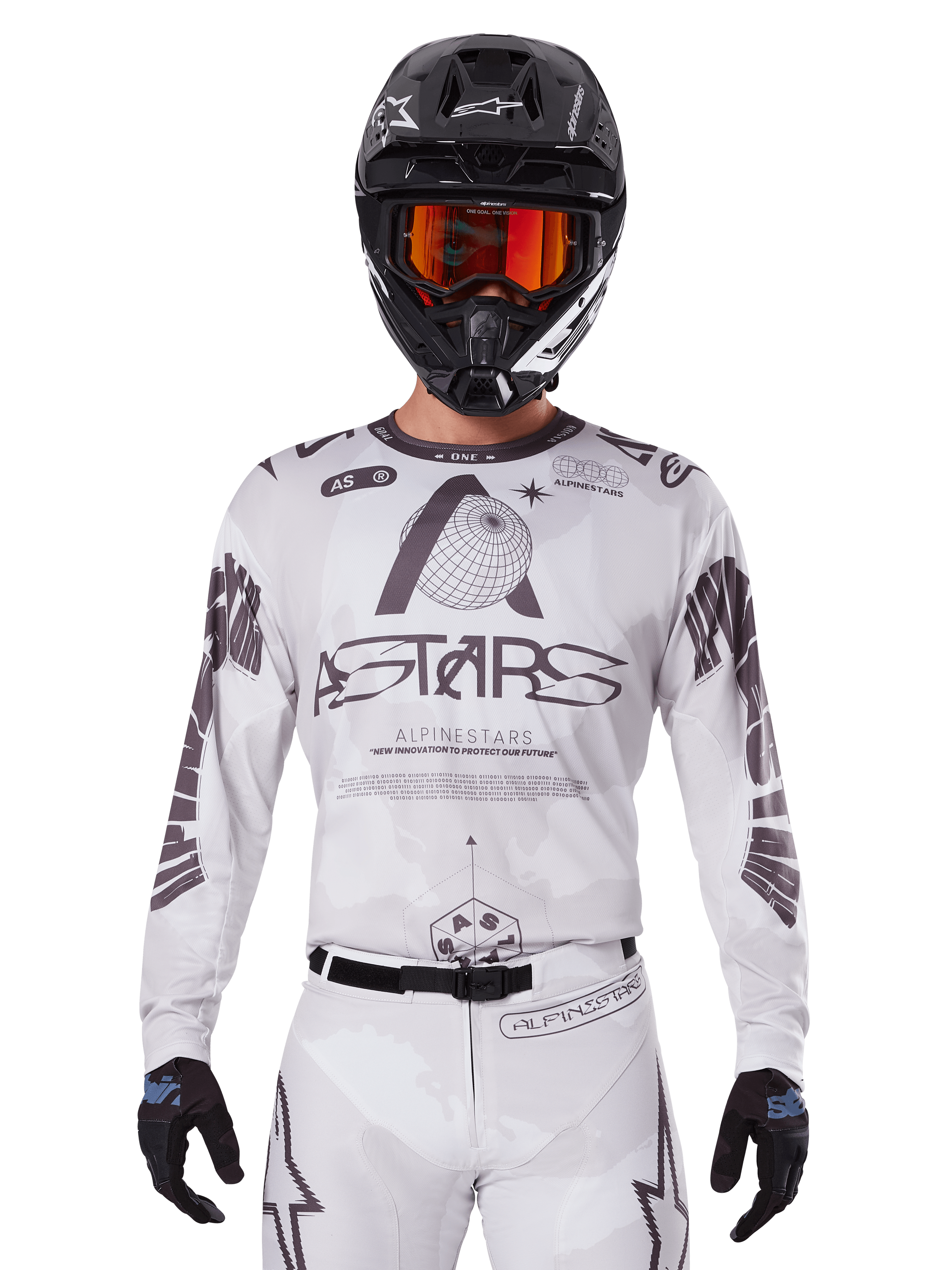 Alpinestars 2025 Racer Hollow Jersey, maglia da motocross bianca e nera, indossata con pantaloni MX bianchi coordinati e un casco nero con maschera arancione, caratterizzata da branding Alpinestars e grafiche a globo, abbigliamento professionale per corse fuoristrada
