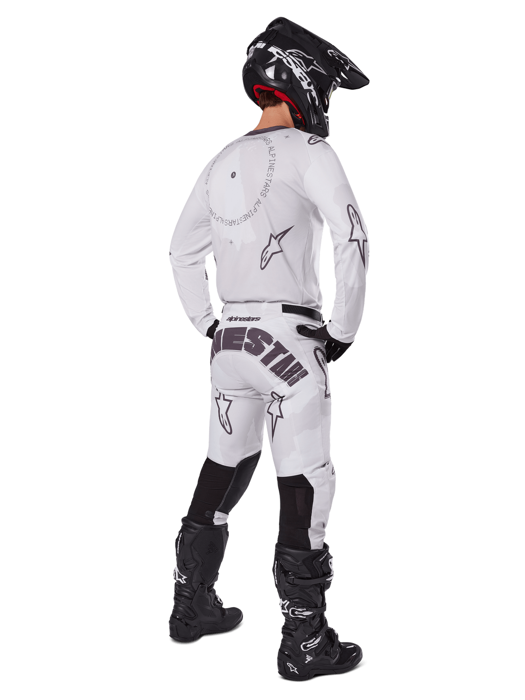 Alpinestars 2025 Racer Hollow Gear Set, bianco, vista posteriore di un pilota di motocross che indossa maglia e pantaloni bianchi con branding nero, casco nero e stivali neri, abbigliamento professionale coordinato per gare fuoristrada