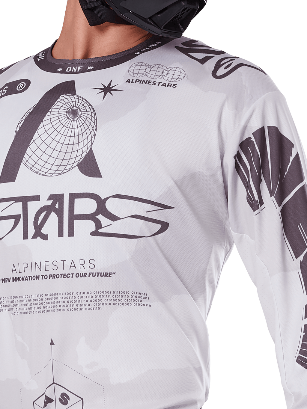 Primo piano della maglia Alpinestars Racer Hollow 2025, bianco e grigio, con stampe grafiche nere, logo del globo e codice binario, abbigliamento tecnico da motocross per la guida fuoristrada