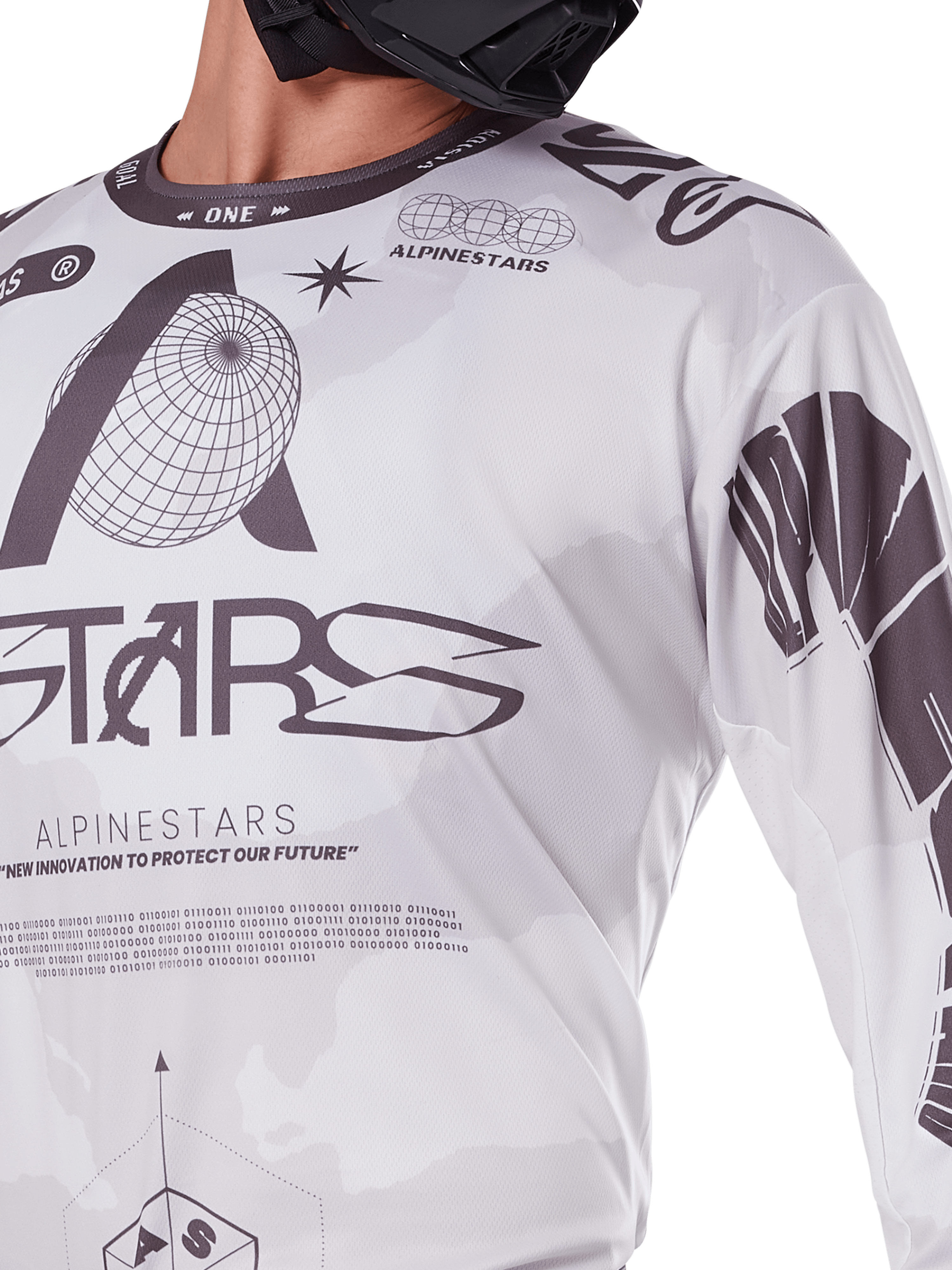Primo piano della maglia Alpinestars Racer Hollow 2025, bianco e grigio, con stampe grafiche nere, logo del globo e codice binario, abbigliamento tecnico da motocross per la guida fuoristrada