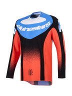 Alpinestars Maglia Techstar Knif 2026, maglia da motocross, arancione, nero e blu UCLA, vista frontale con pannello blu sul petto e logo Alpinestars bianco, sfumatura nera punteggiata su maniche e corpo arancioni, abbigliamento tecnico da gara off-road
