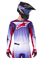 Alpinestars 2025 Fluid Wurx Jersey, maglia da motocross, sfumatura da viola a bianco, logo a stella rosso e accenti rossi, vestibilità atletica, indossata con pantaloni coordinati, casco nero e guanti rossi