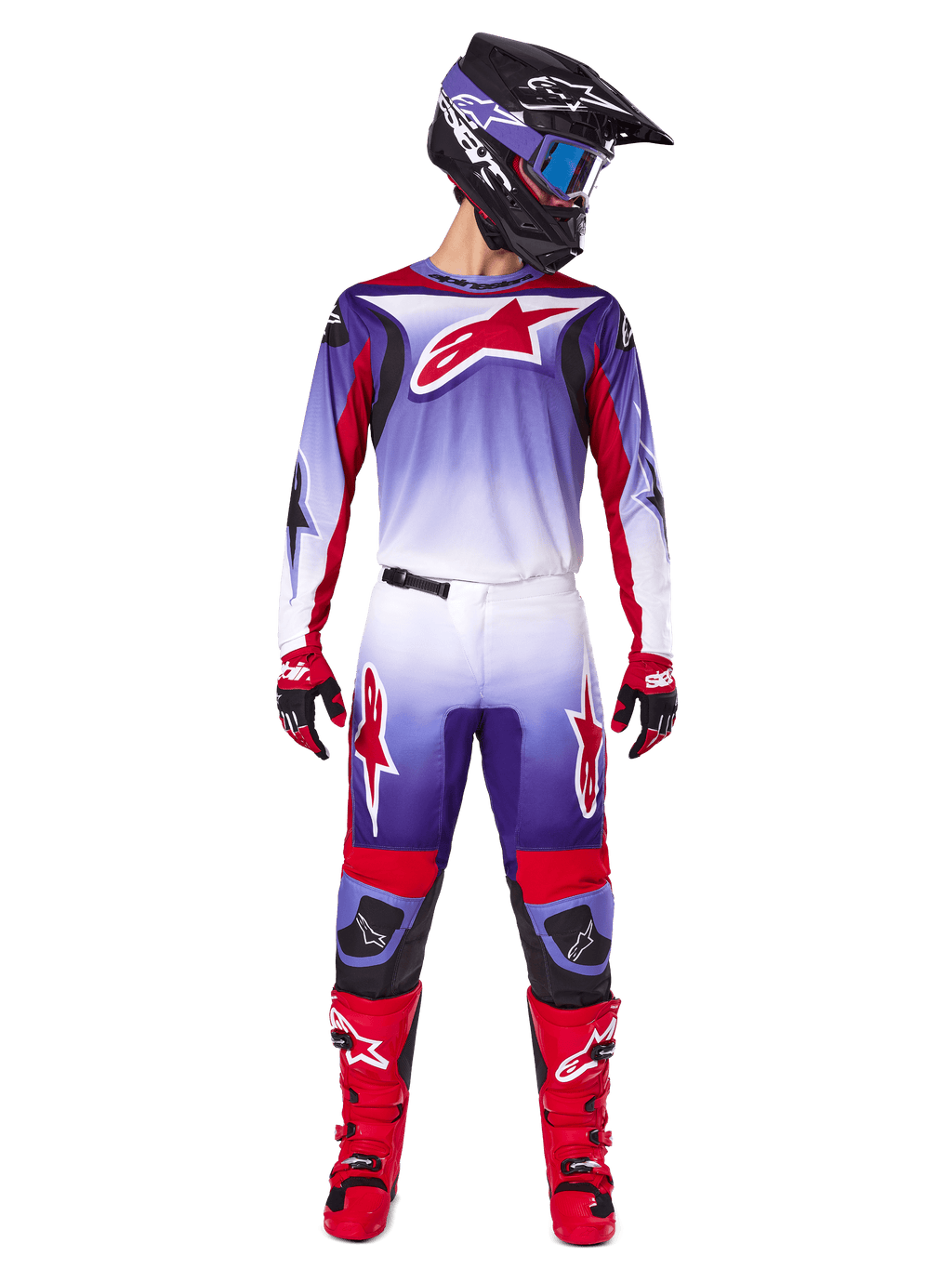 Pilota di motocross con abbigliamento completo Alpinestars, maglia Fluid Wurx 2025 in Purple Bright Red con dettagli bianchi e grande logo a stella rosso, pantaloni coordinati, stivali rossi e casco nero con occhiali, outfit coordinato per gare fuoristrada