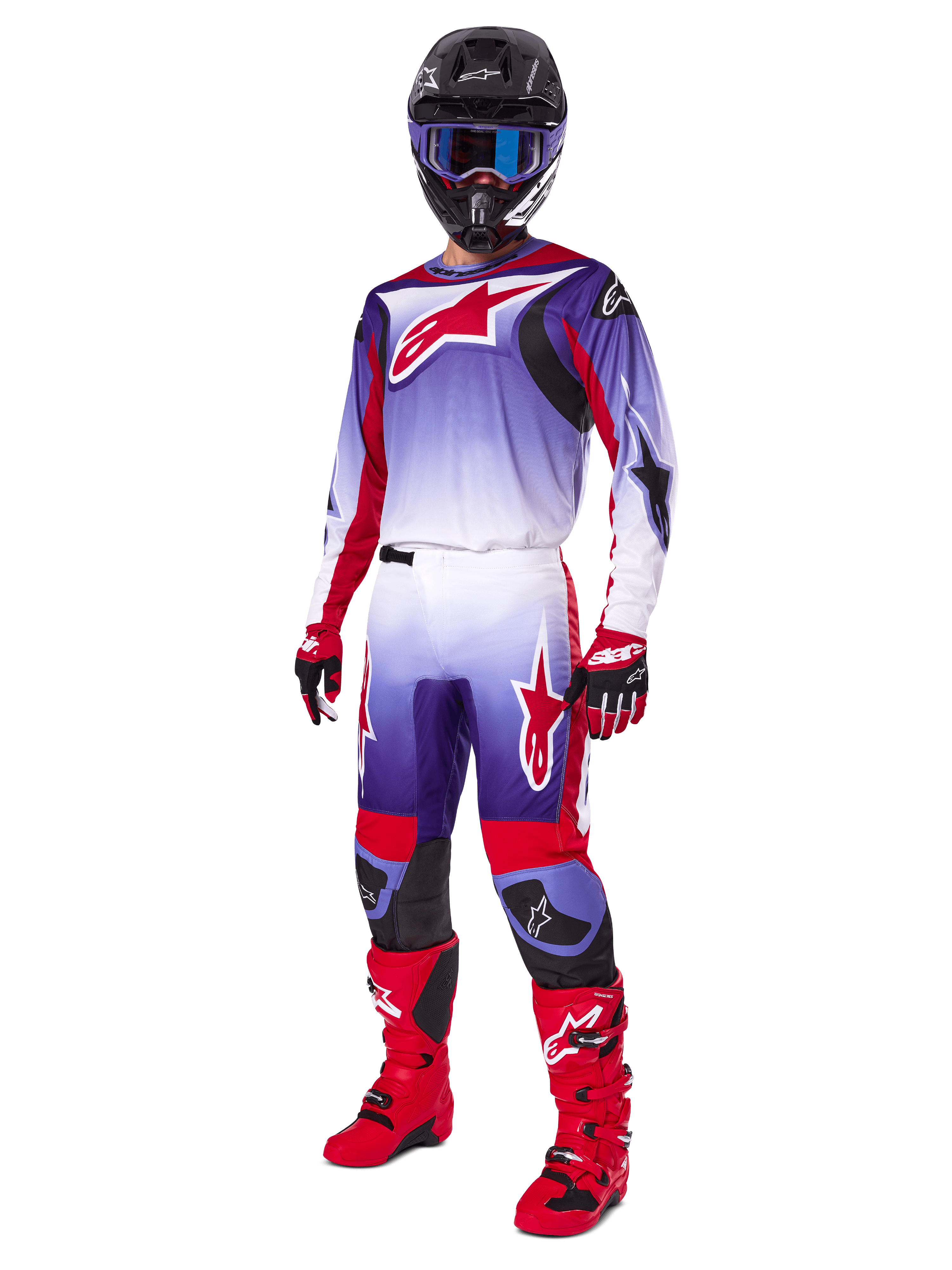 Pilota di motocross con completo Alpinestars 2025 Fluid Wurx, maglia viola e rosso acceso con accenti bianchi, pantaloni da motocross coordinati, stivali rosso acceso, casco nero con maschera blu e guanti rossi e neri, kit professionale completo per fuoristrada