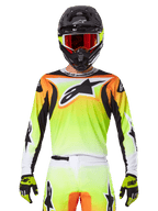 Alpinestars 2025 Fluid Wurx Jersey, maglia da motocross, giallo neon, arancione e bianco, indossata con pantaloni coordinati e casco nero con occhiali rossi, completo da motocross su pilota