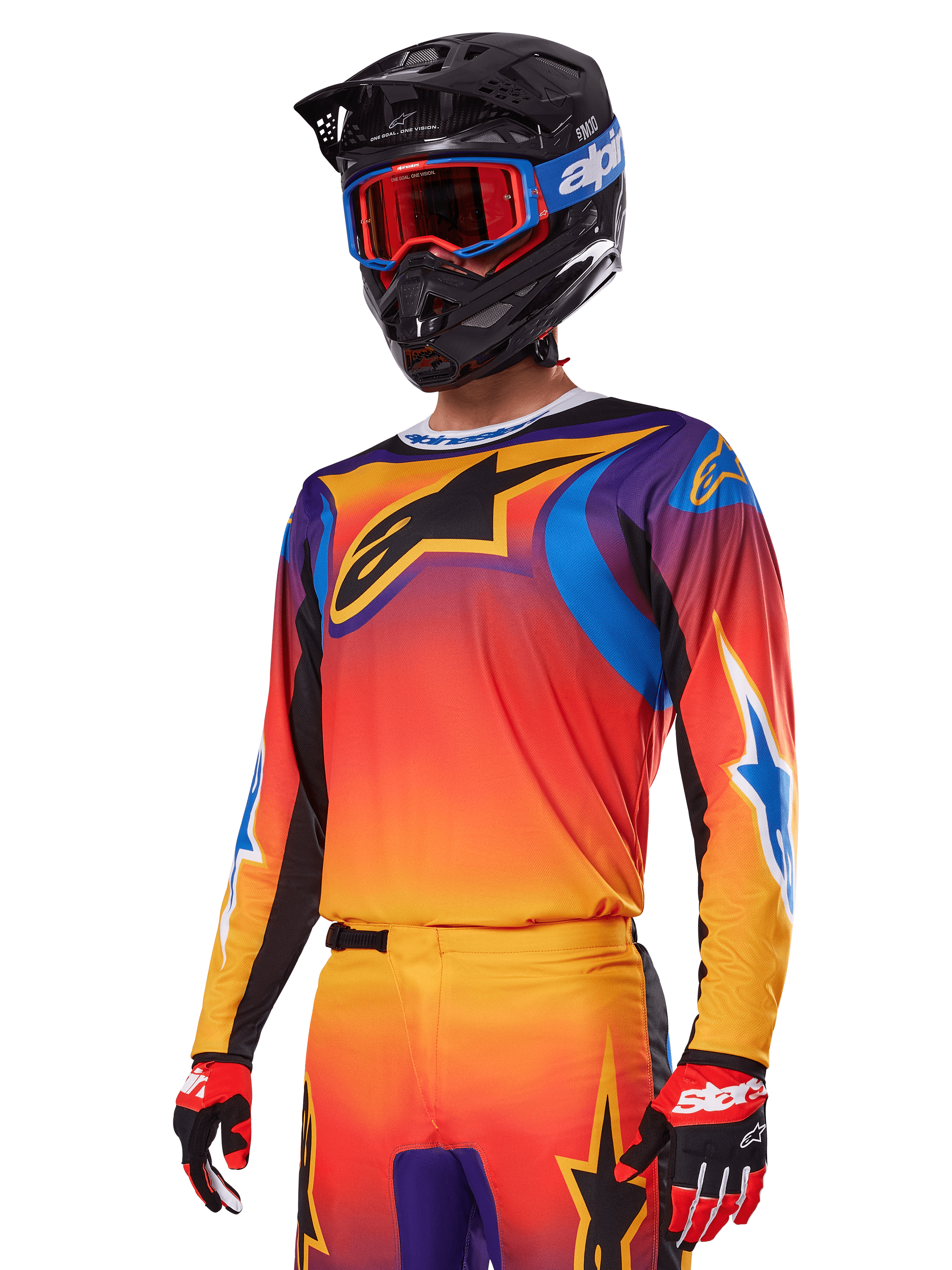Alpinestars 2025 Fluid Wurx Gear Set, completo da motocross, sfumatura arancione, viola e blu, con un grande logo A-stars nero, indossato con casco nero e occhiali blu, outfit coordinato per gare off-road professionali