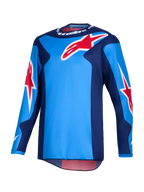 Alpinestars Fluid Grid Jersey 2026, maglia da motocross, blu e rossa, caratterizzata da grandi loghi a stella rossi Alpinestars, pannelli laterali blu scuro e costruzione in poliestere leggero con taglio posteriore allungato per la guida off-road.