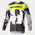 Alpinestars 2023 Racer Tactical Jersey, maglia da motocross, Cast Gray Camo e Giallo Fluo, caratterizzata da un motivo mimetico grigio e nero con un pannello giallo brillante sul petto e logo Alpinestars, abbigliamento tecnico a maniche lunghe resistente per corse off-road