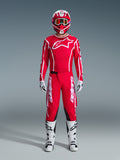 Alpinestars 2026 Fluid Apex Gear Set, completo da motocross rosso e bianco, kit racing completo con maglia rossa a maniche lunghe e logo a stella bianco, pantaloni rossi con marchio bianco e pannelli neri alle ginocchia, stivali bianchi con dettagli neri, guanti bianchi e casco coordinato con maschera, abbigliamento professionale da fuoristrada.