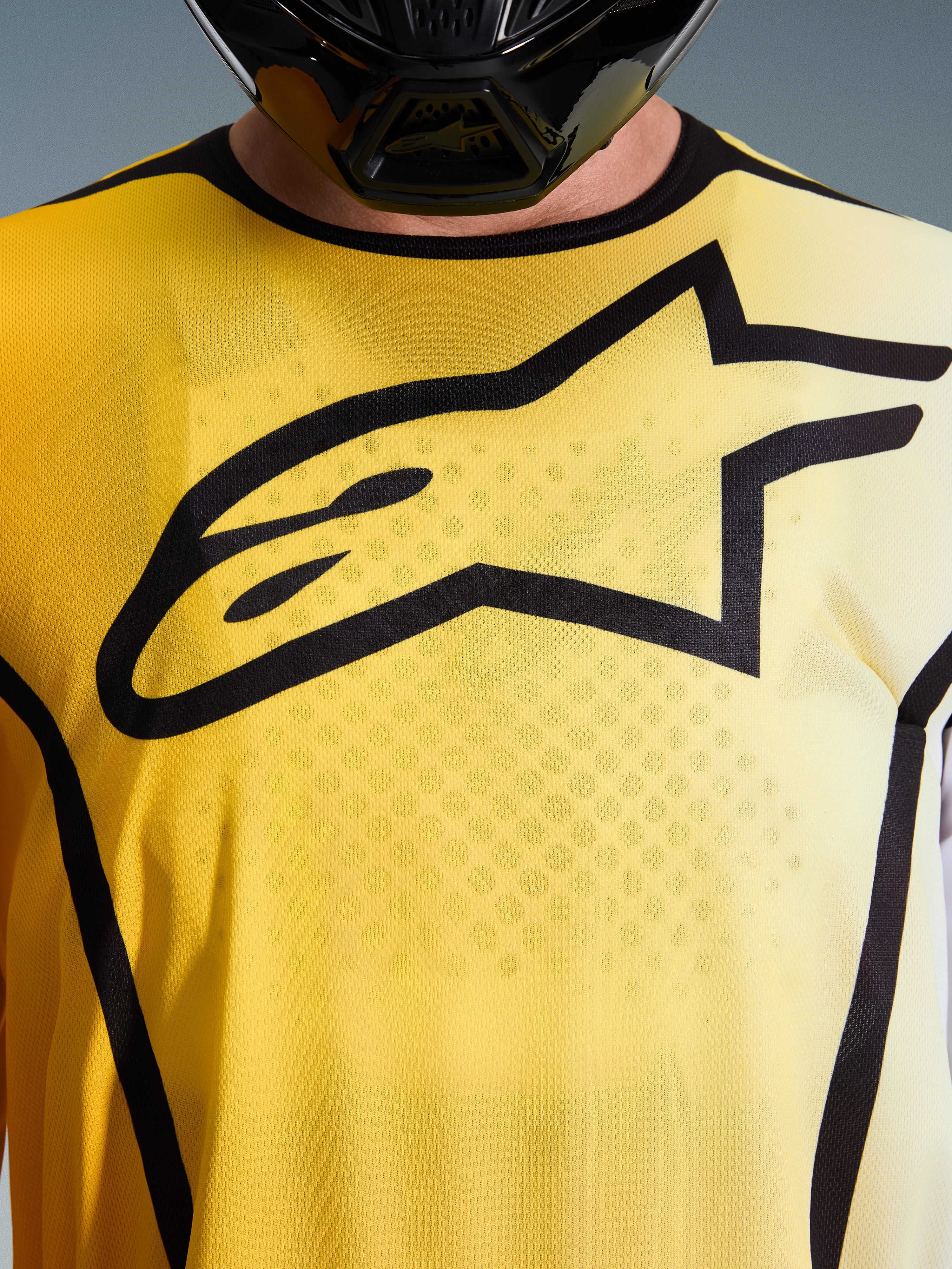 Alpinestars 2026 Fluid Apex Jersey, maglia da motocross, giallo brillante e nero, vista ravvicinata con grande logo Astar nero sul petto, tessuto poly-fabric traspirante con colletto sportivo