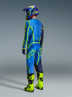 Alpinestars 2026 Fluid Apex Gear Set, pilota di motocross visto di spalle con completo blu e giallo neon, maglia e pantaloni blu con loghi giallo neon, stivali giallo neon, casco viola e blu, abbigliamento tecnico da motocross coordinato