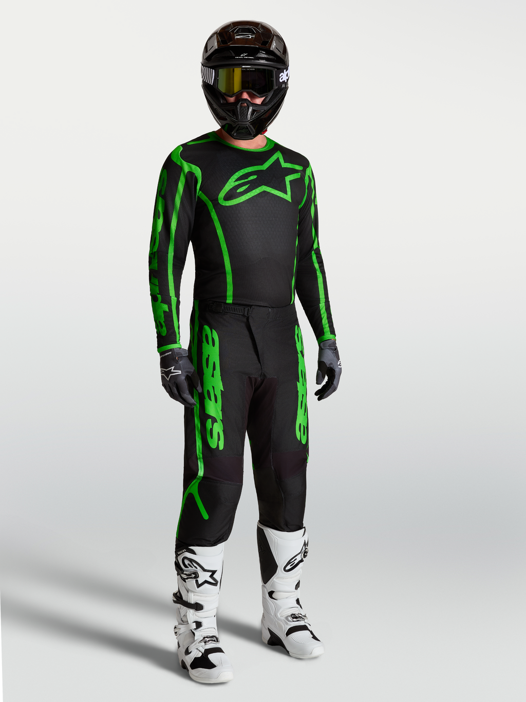Alpinestars pantaloni Fluid Apex V2, completo motocross uomo nero e verde fluo, resistente, con stivali bianchi.