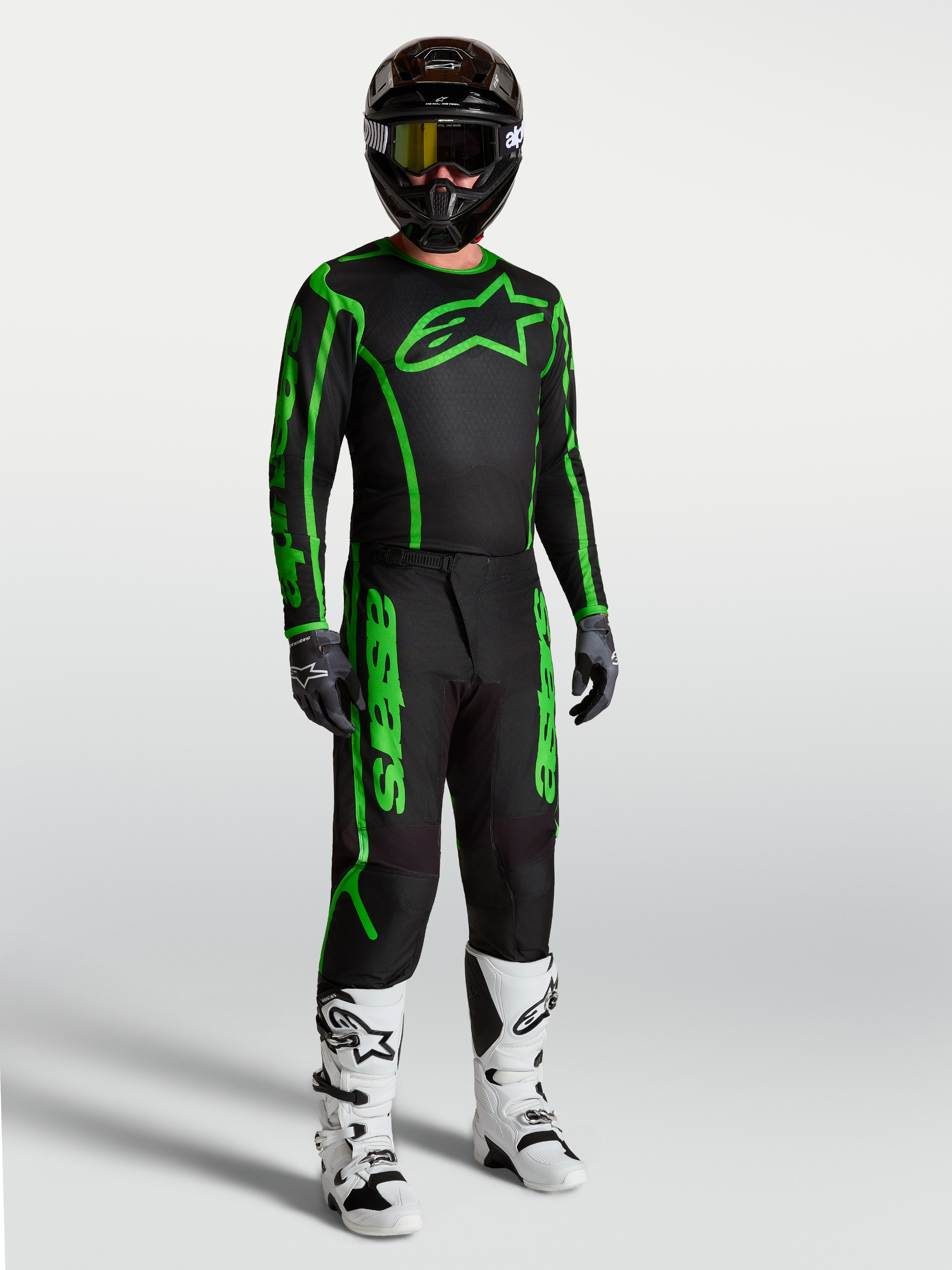 Alpinestars pantaloni Fluid Apex V2, completo motocross uomo nero e verde fluo, resistente, con stivali bianchi.