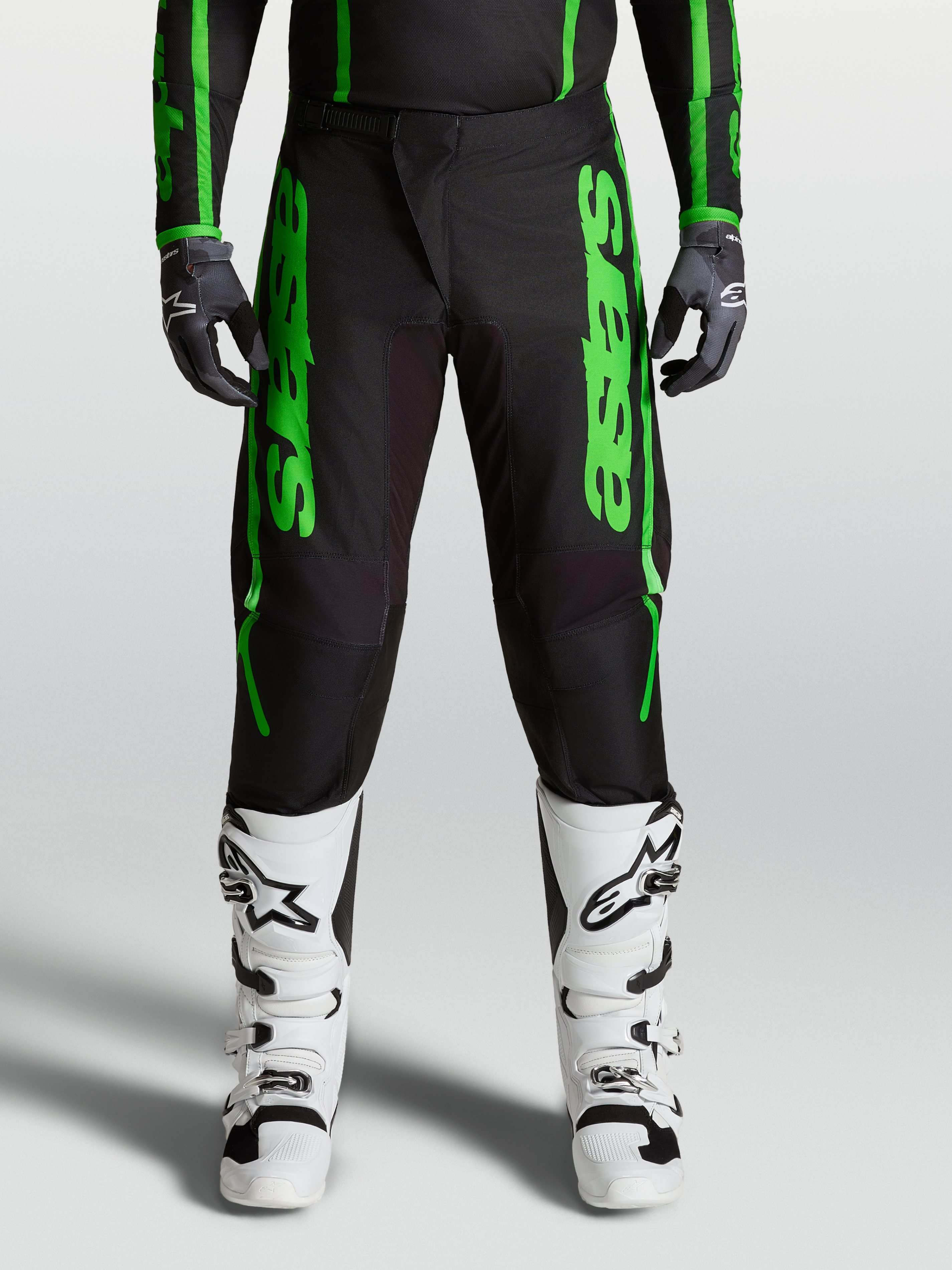 Alpinestars Pantaloni Fluid Apex V2 2027, pantaloni motocross uomo neri e verdi, ginocchia rinforzate e stivali bianchi