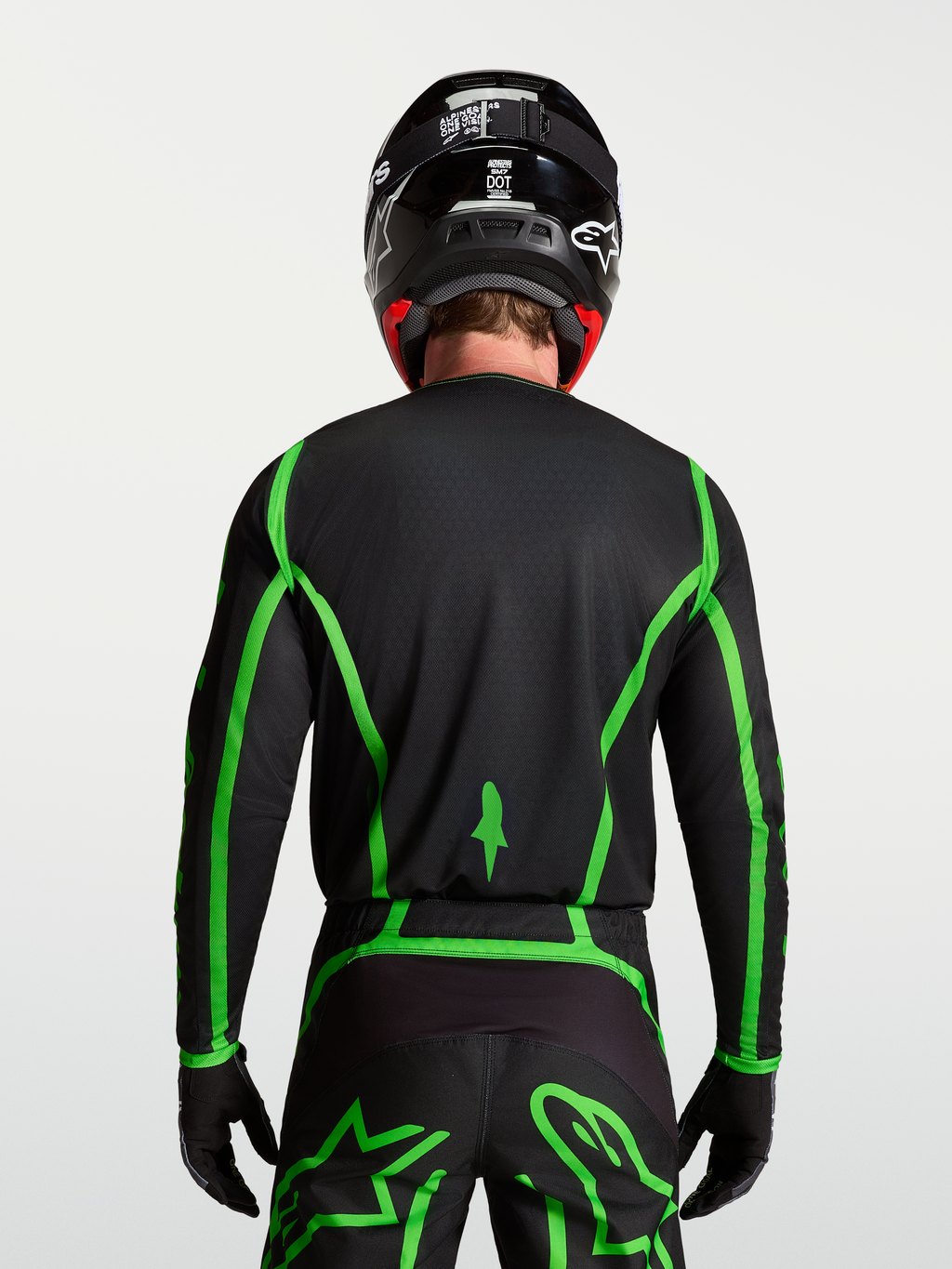 Alpinestars Maglia Fluid Apex V2, maglia da motocross per uomo, nera e verde fluorescente, vista posteriore su modello con retro allungato per maggiore copertura