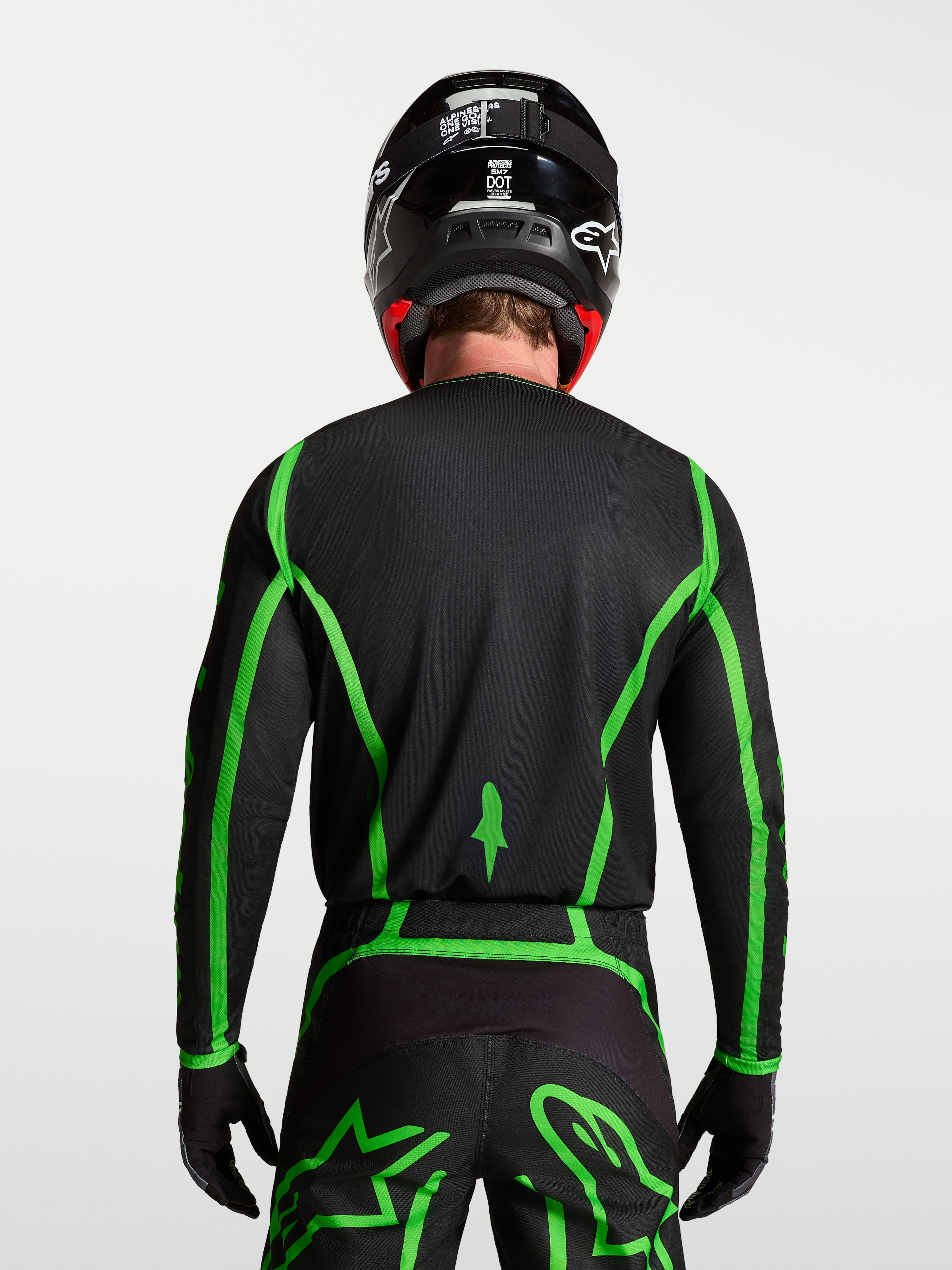 Alpinestars Maglia Fluid Apex V2, maglia da motocross per uomo, nera e verde fluorescente, vista posteriore su modello con retro allungato per maggiore copertura