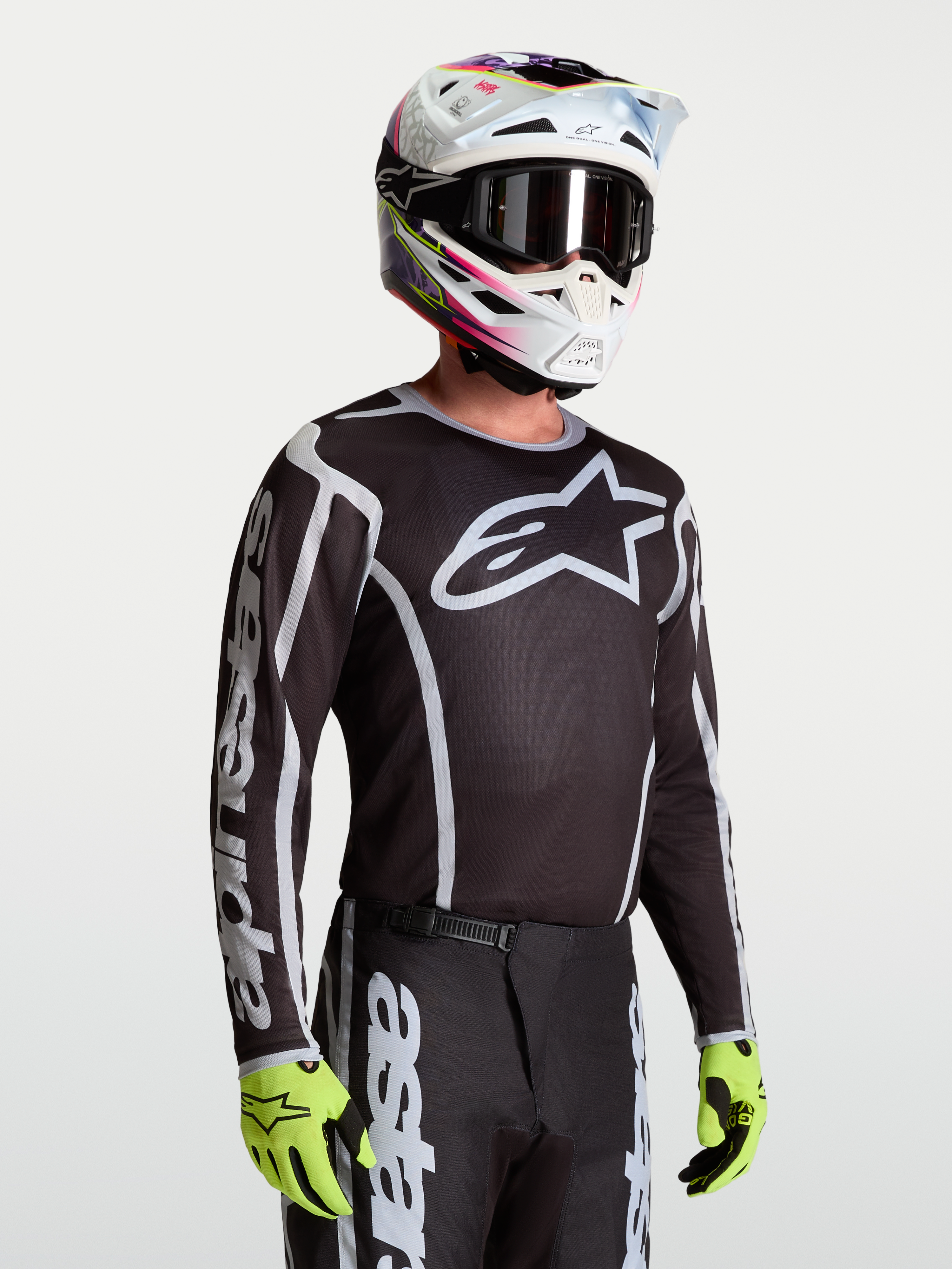 Alpinestars Maglia Fluid Apex V2, maglia da motocross da uomo, nero e argento, traspirante, indossata con casco.