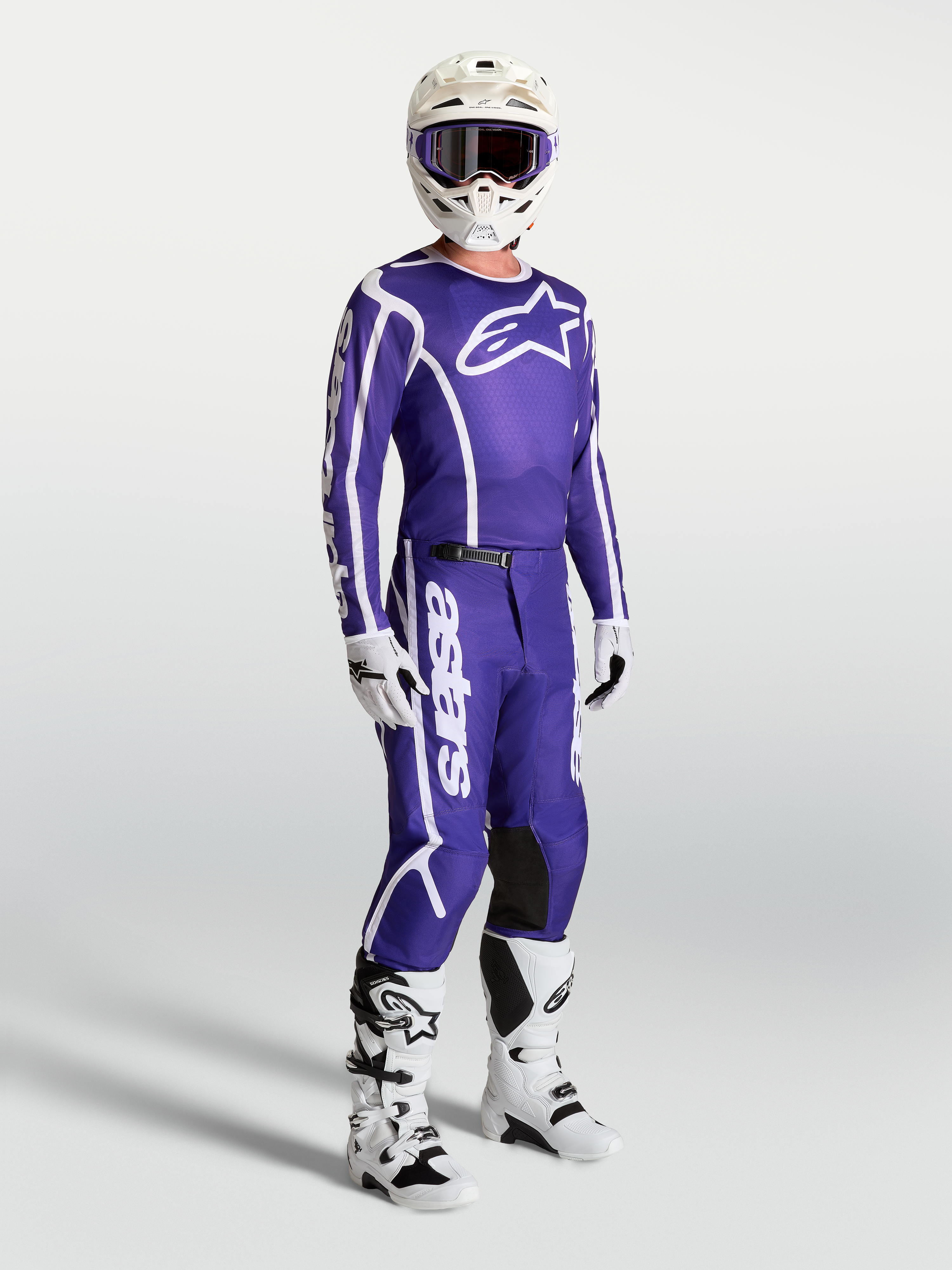 Alpinestars maglia Fluid Apex V2 e pantaloni, completo motocross per uomo, blu e bianco, con casco e stivali bianchi.